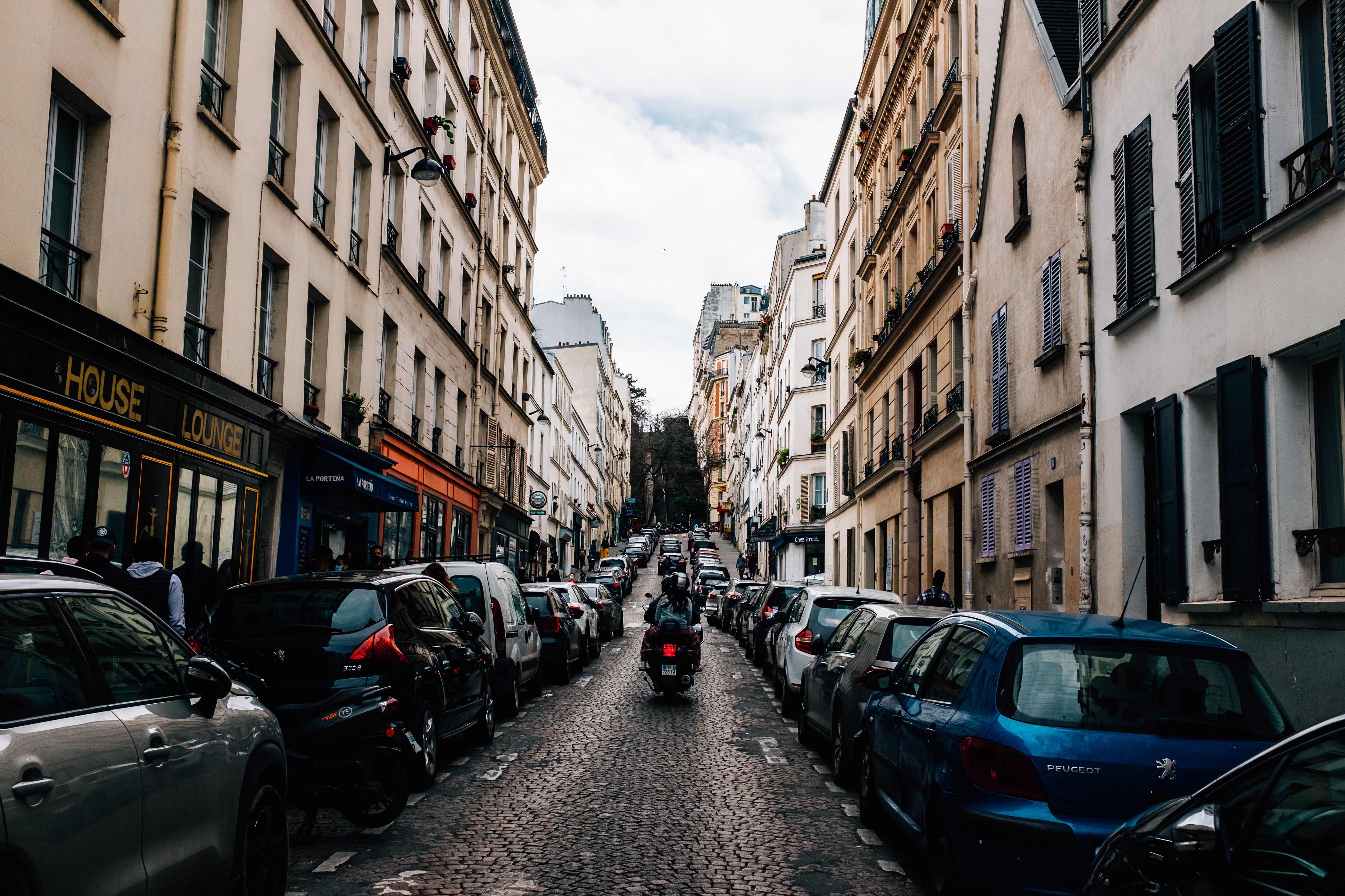 Moto montant dans une rue pavée étroite – Photo