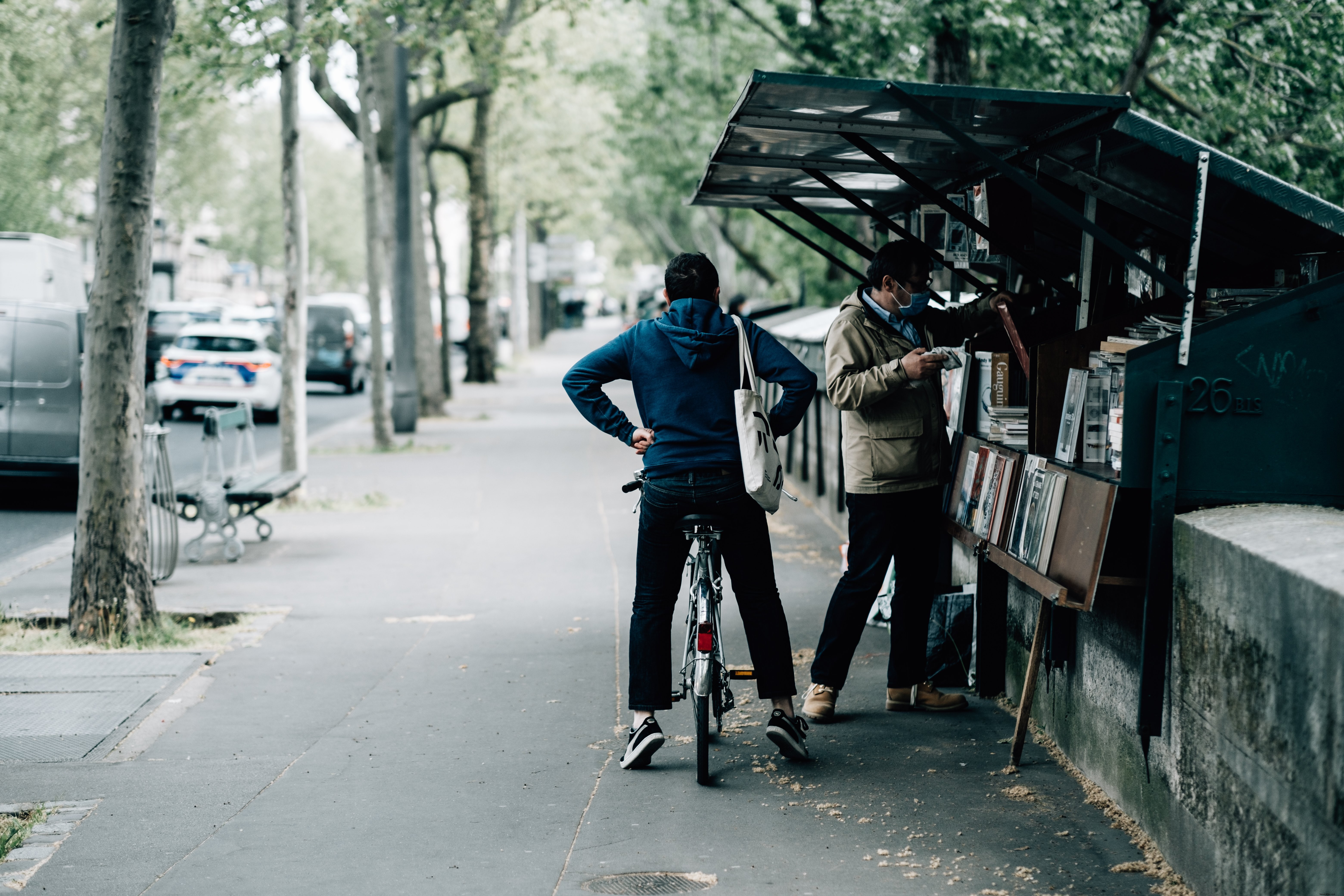 Un cycliste attend que son ami achète des livres photo