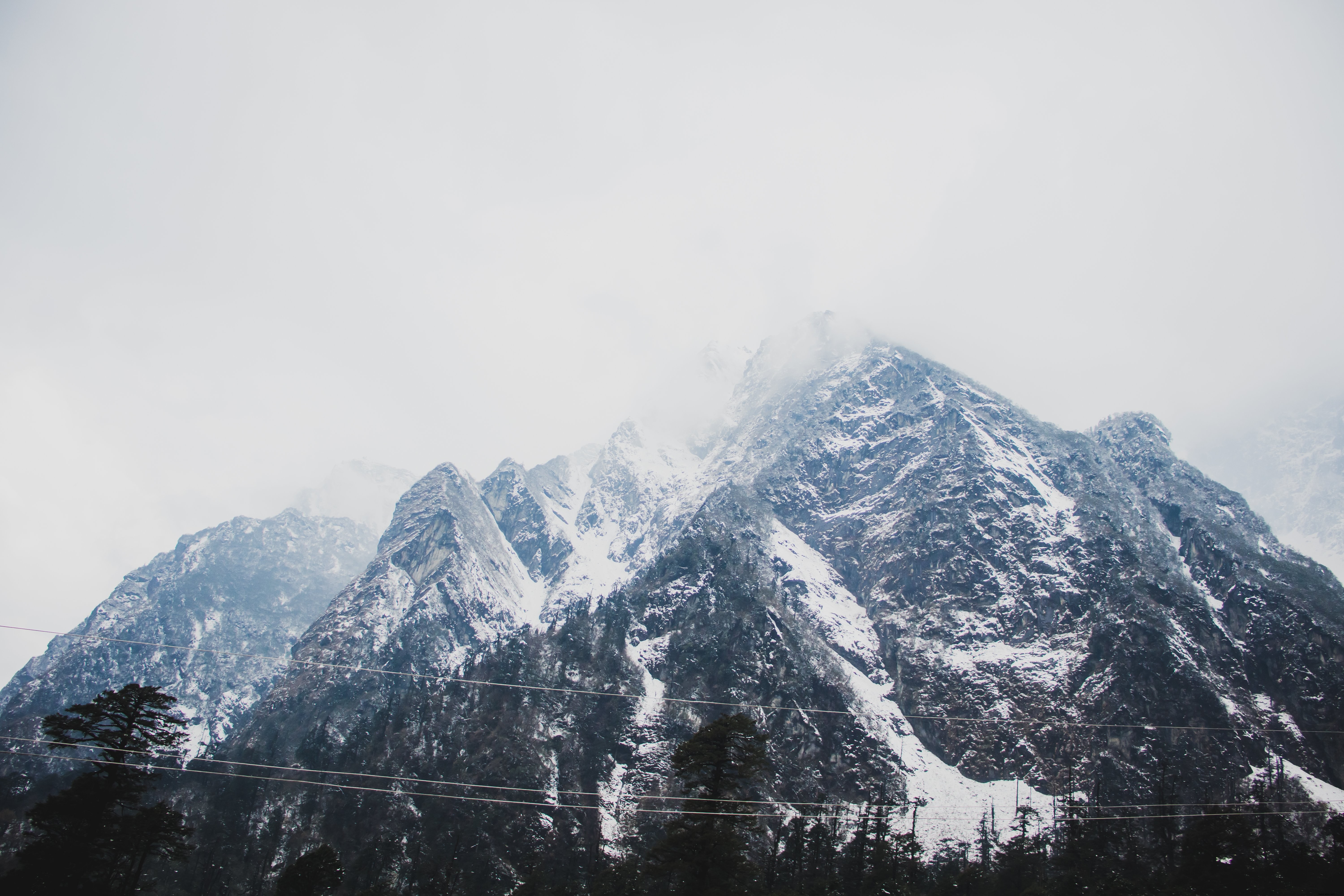 Photo de montagnes enneigées sous les nuages