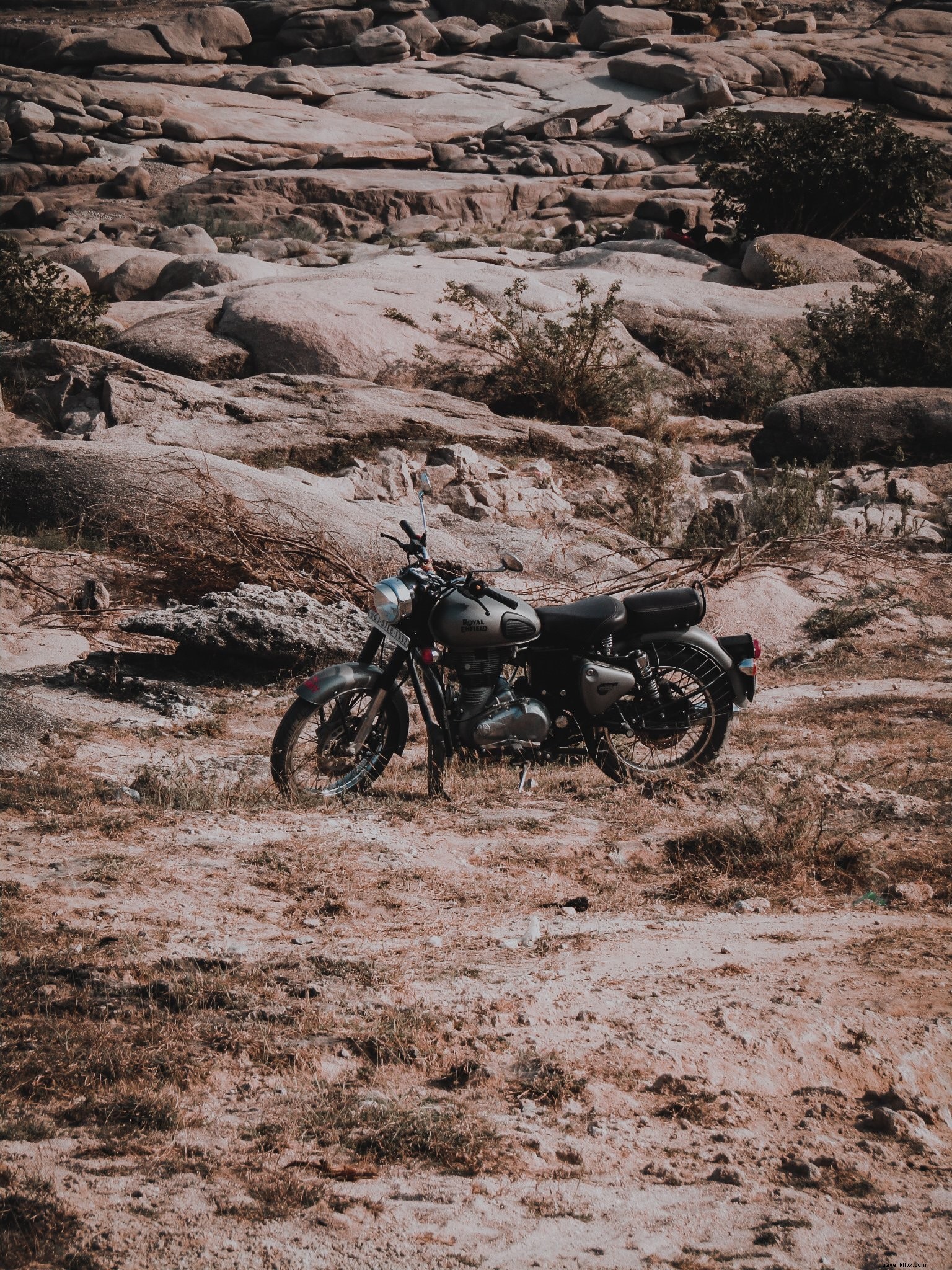 Photo d une moto noire garée devant une colline de pierres