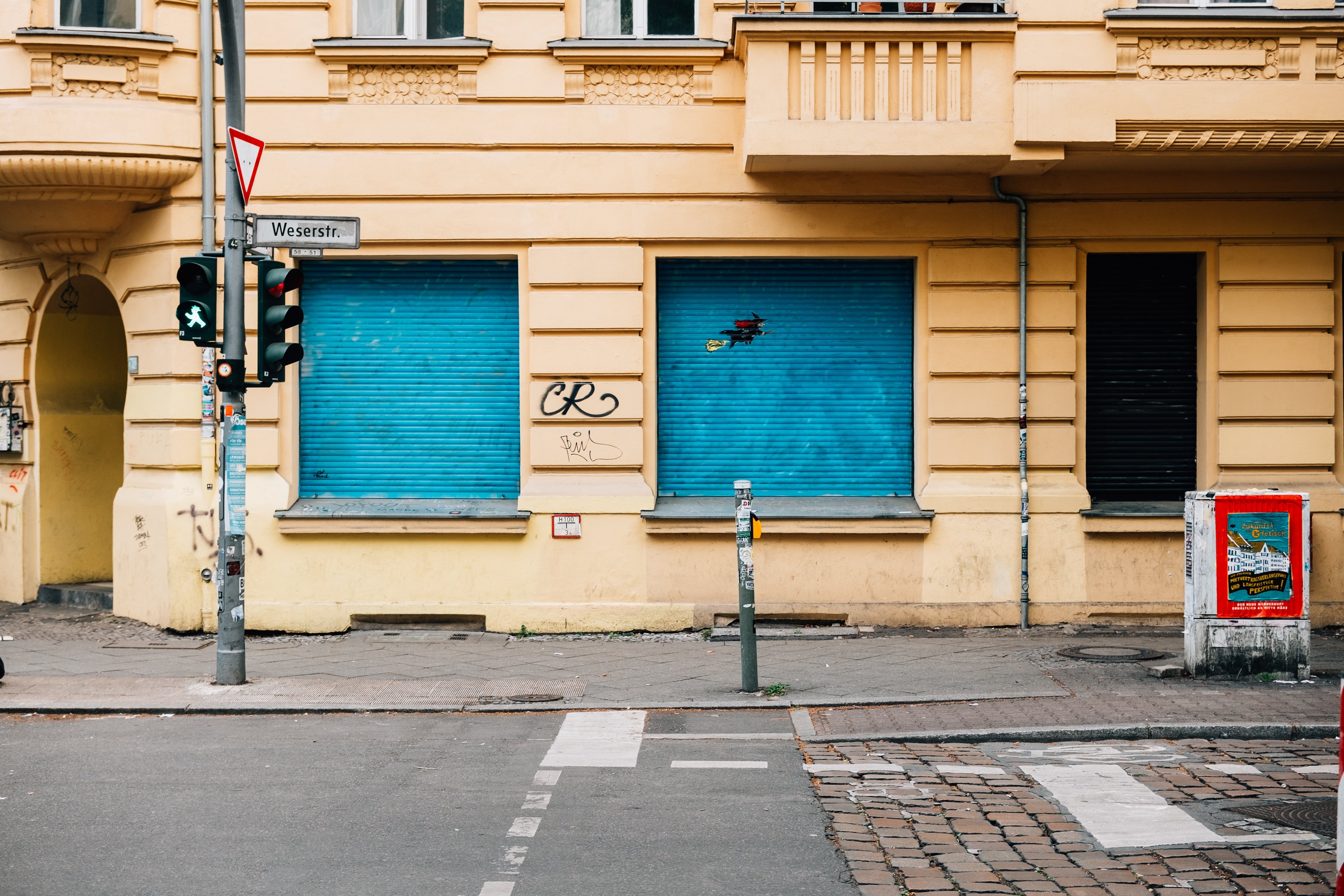 Photo d un bâtiment jaune en ville avec des stores bleus