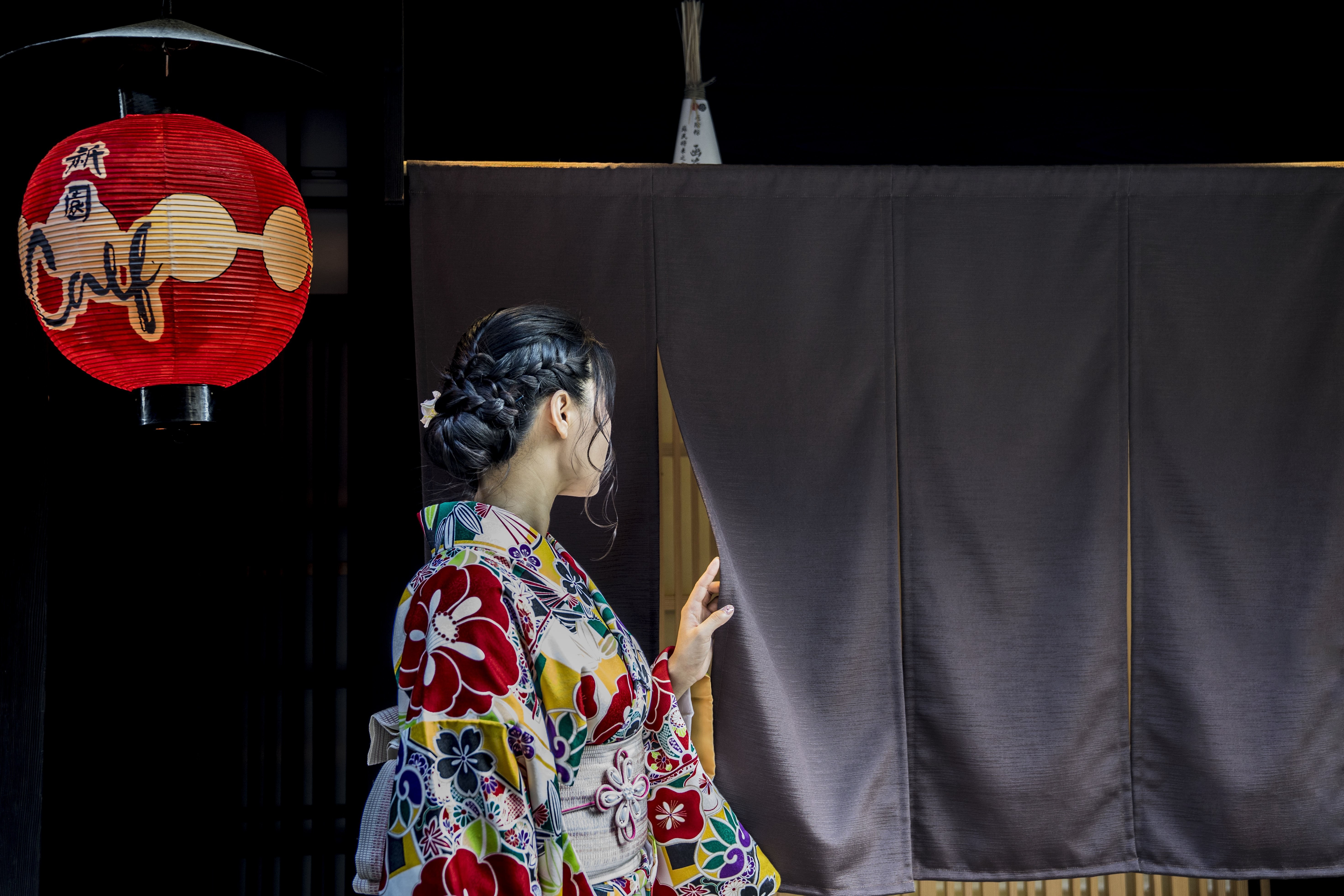 Photo d une personne en kimono derrière un rideau noir