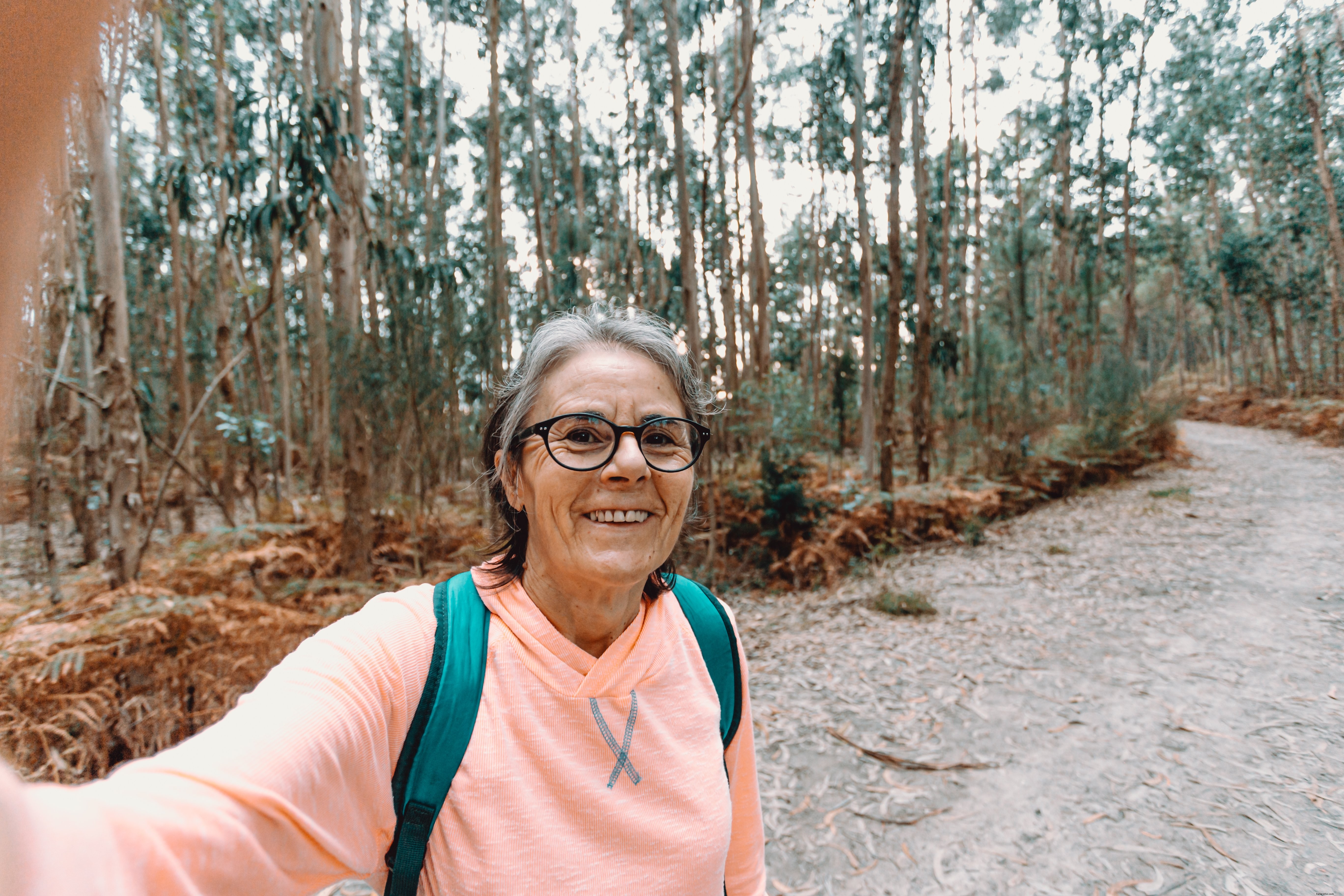 Femme souriante se prend en selfie pendant une randonnée photographique