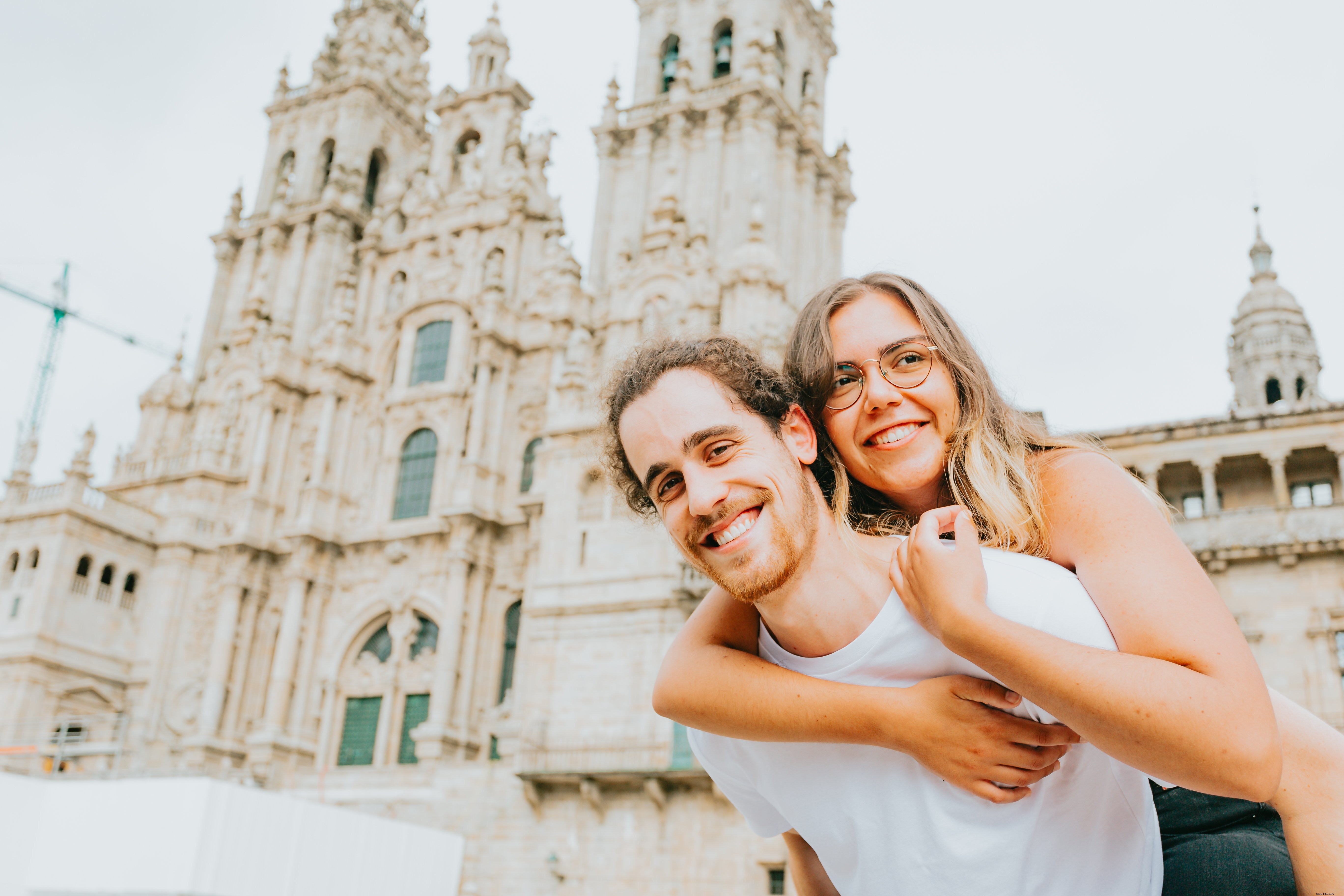 Un homme porte une femme sur son dos, tous deux sourient