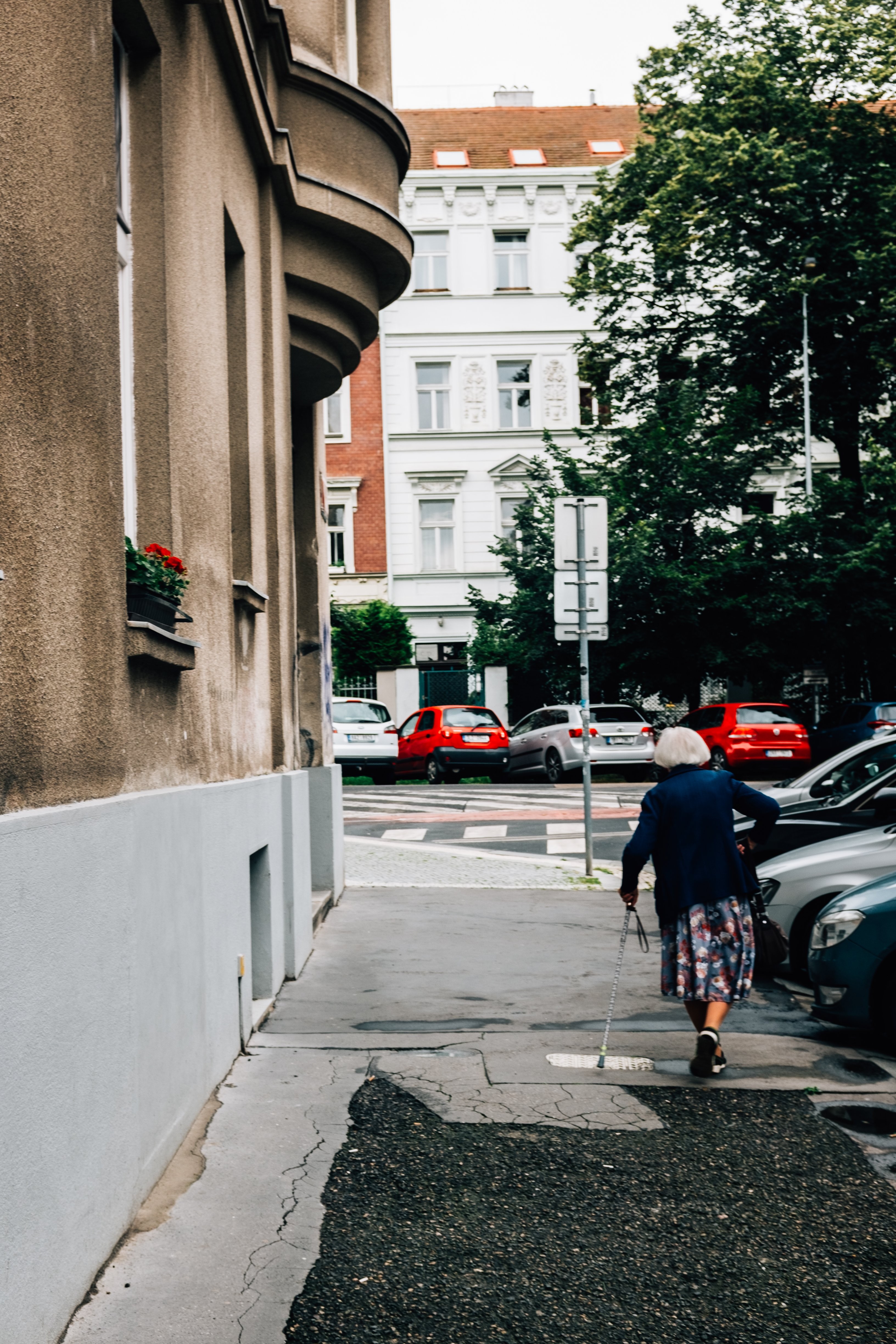 Individu marchant sur le trottoir avec une canne