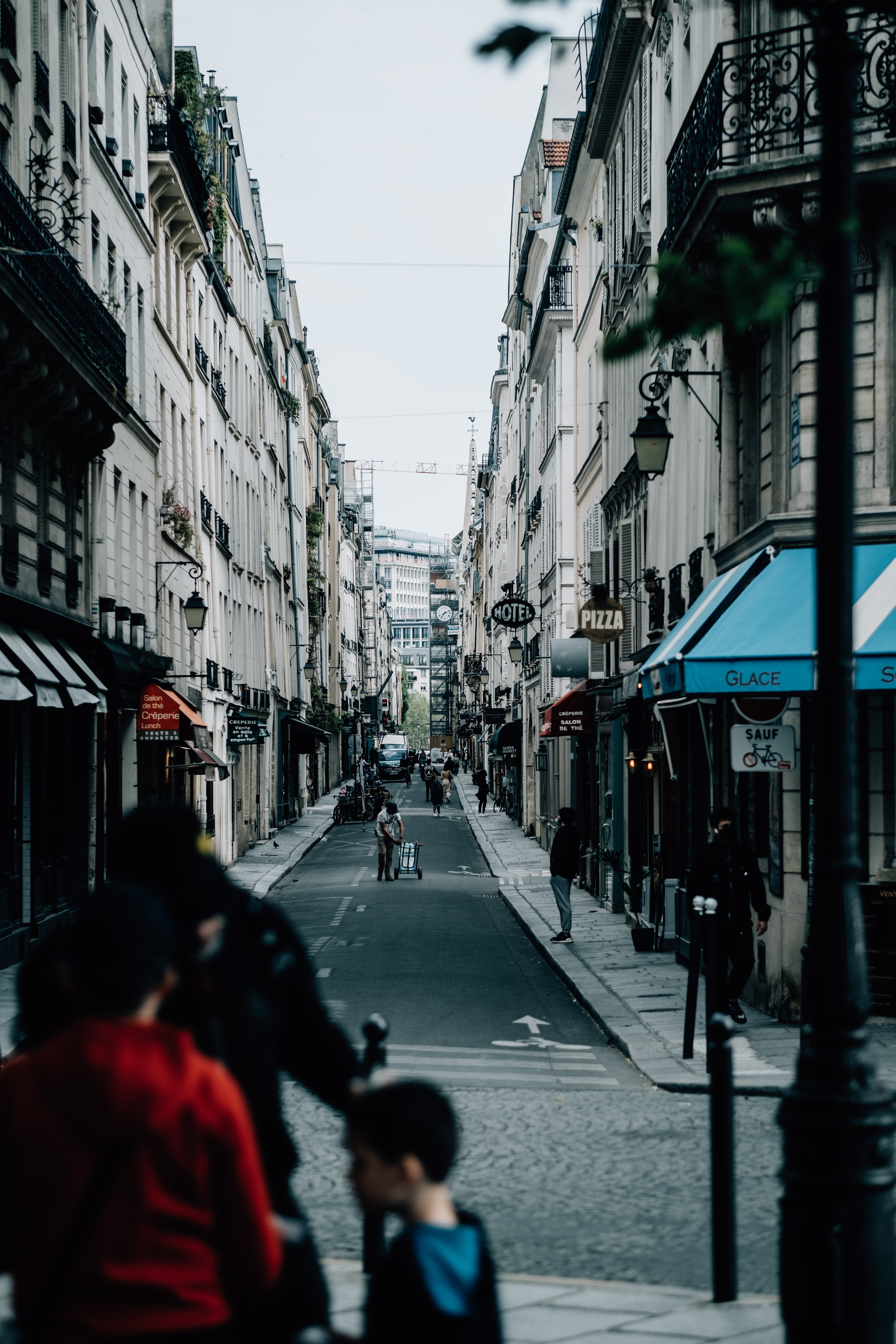 Photo d’une rue étroite du centre‑ville avec des piétons