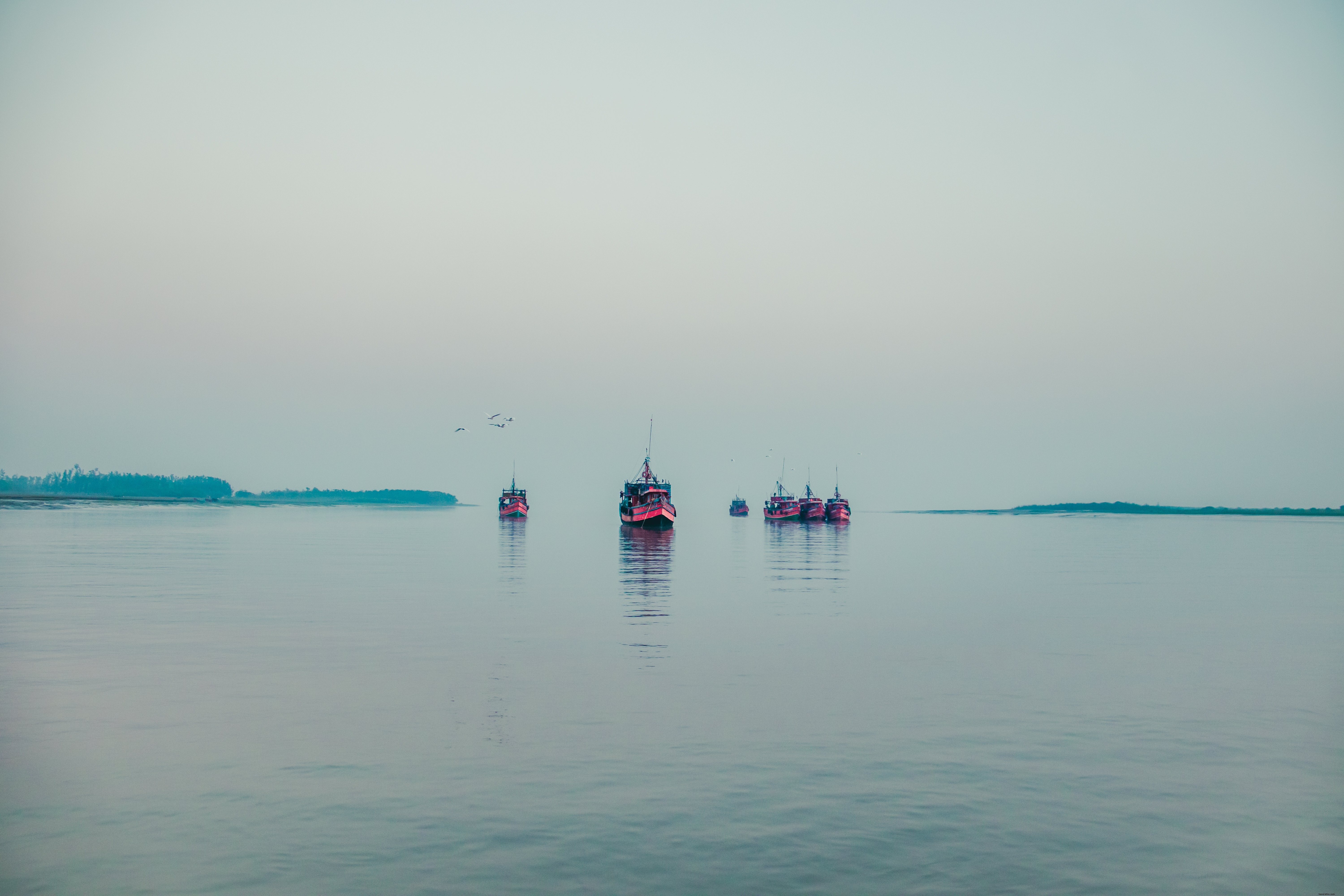 Photo : Bateaux rouges flottant sur l eau sous un ciel couvert