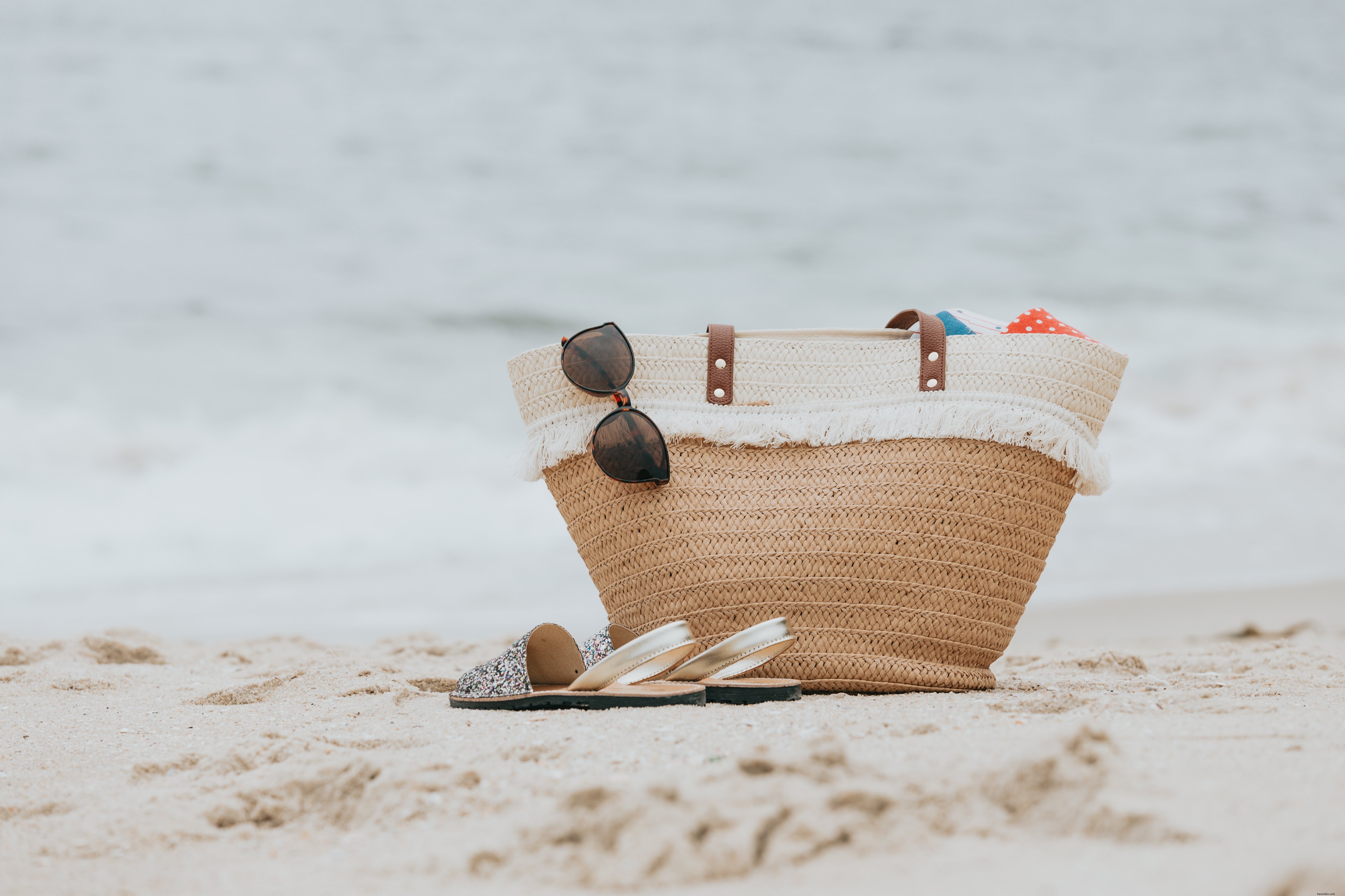 Sandales et sac de plage sur une plage de sable blanc