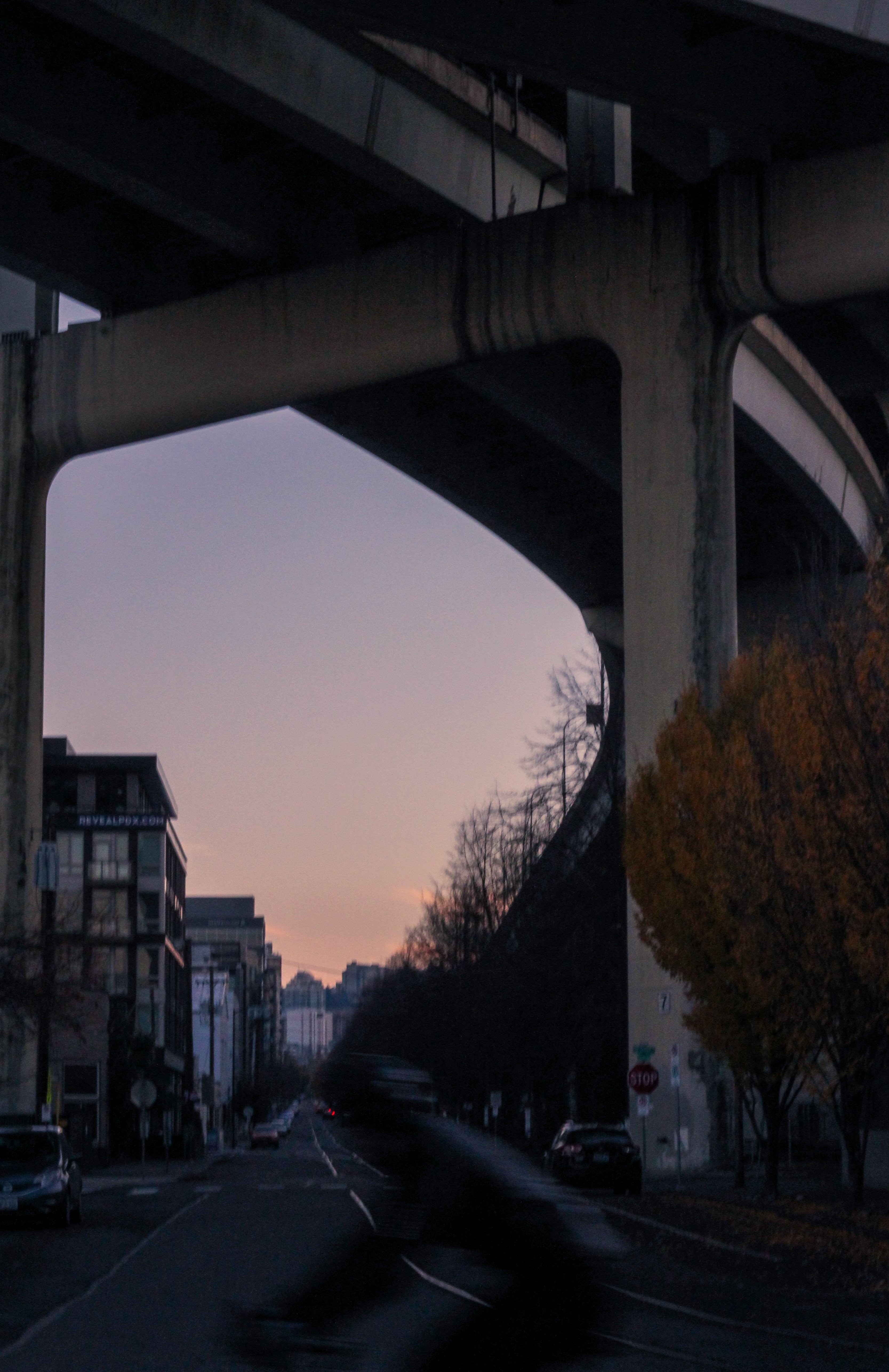 Coucher de soleil derrière les bâtiments de la ville sous le pont