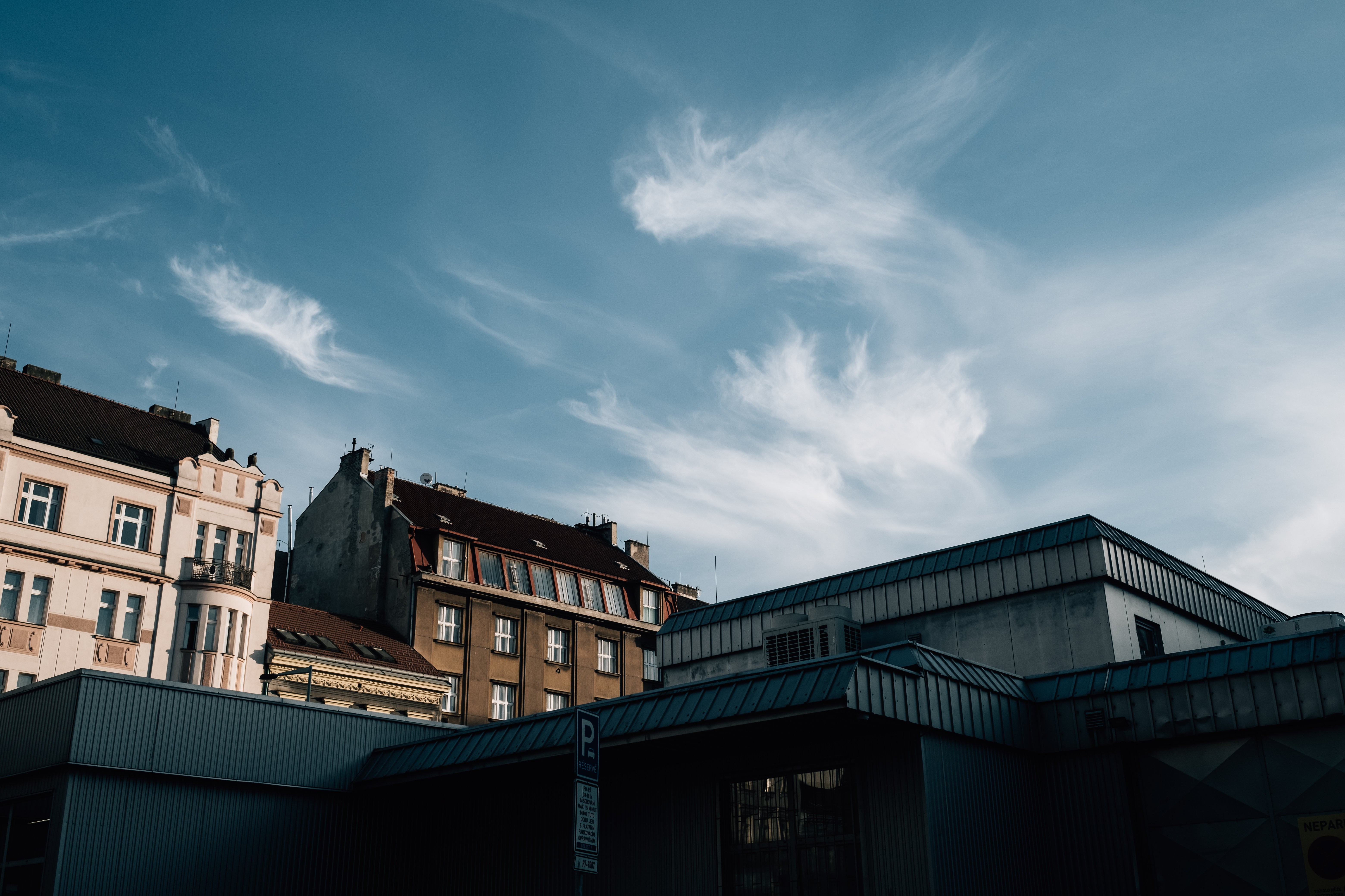 Ciel bleu et nuages vaporeux sur les toits des bâtiments