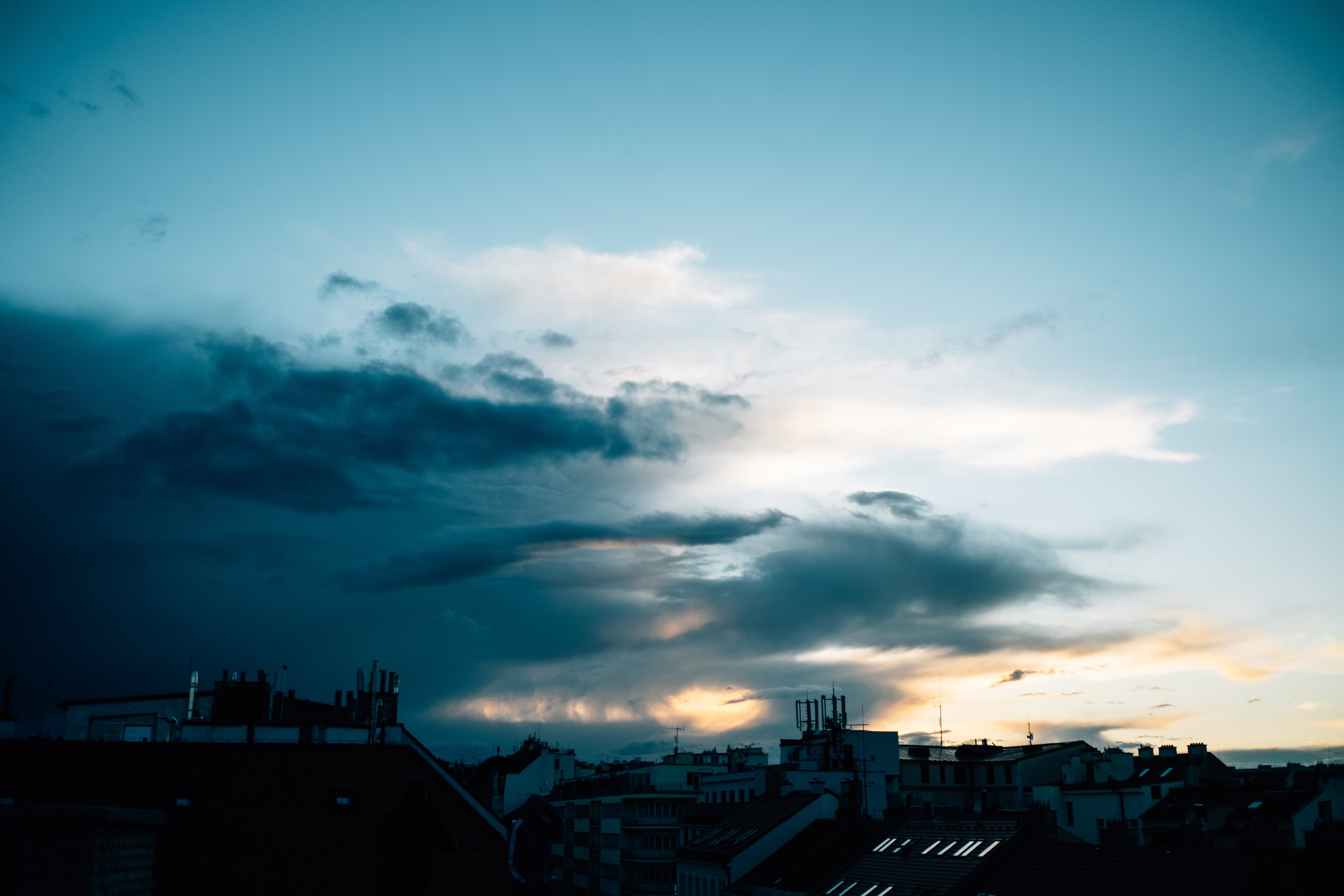Coucher de soleil sur une ville, avec des nuages orageux qui défilent