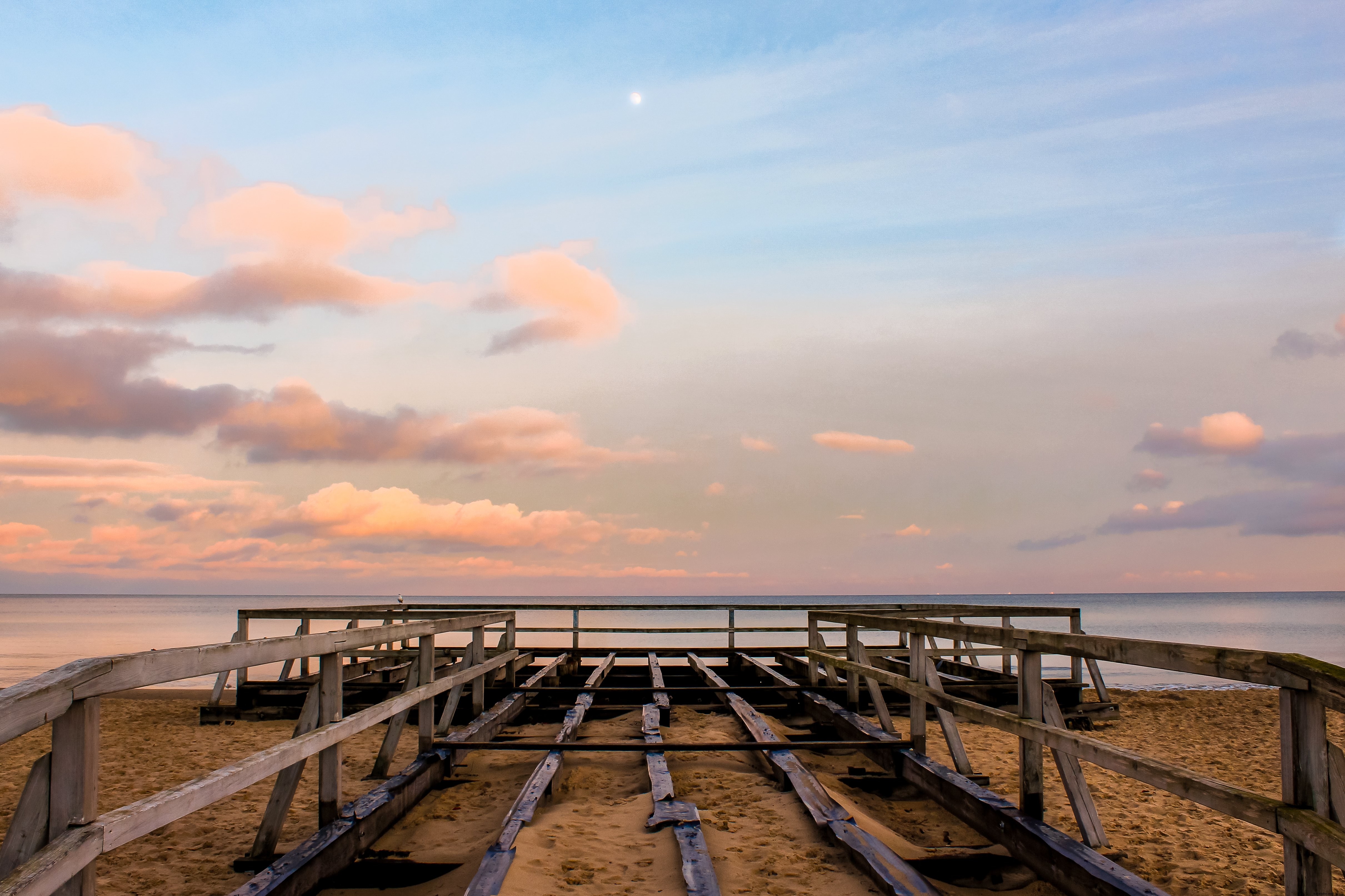 Photo d’une structure en bois s’étendant jusqu’à l’eau au coucher du soleil