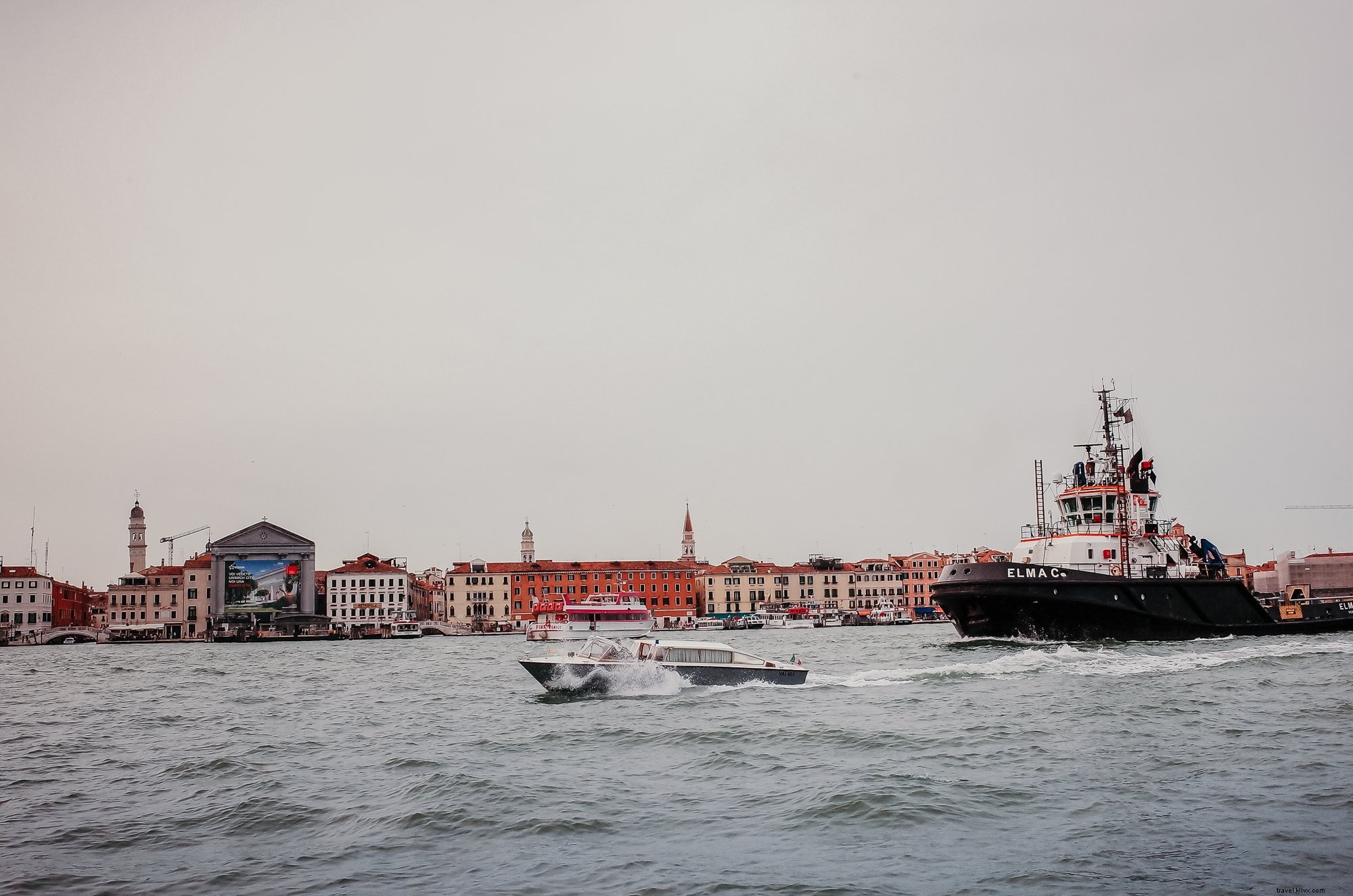 Bateaux sur des eaux ondulées, rivage bordé de bâtiments – Photo