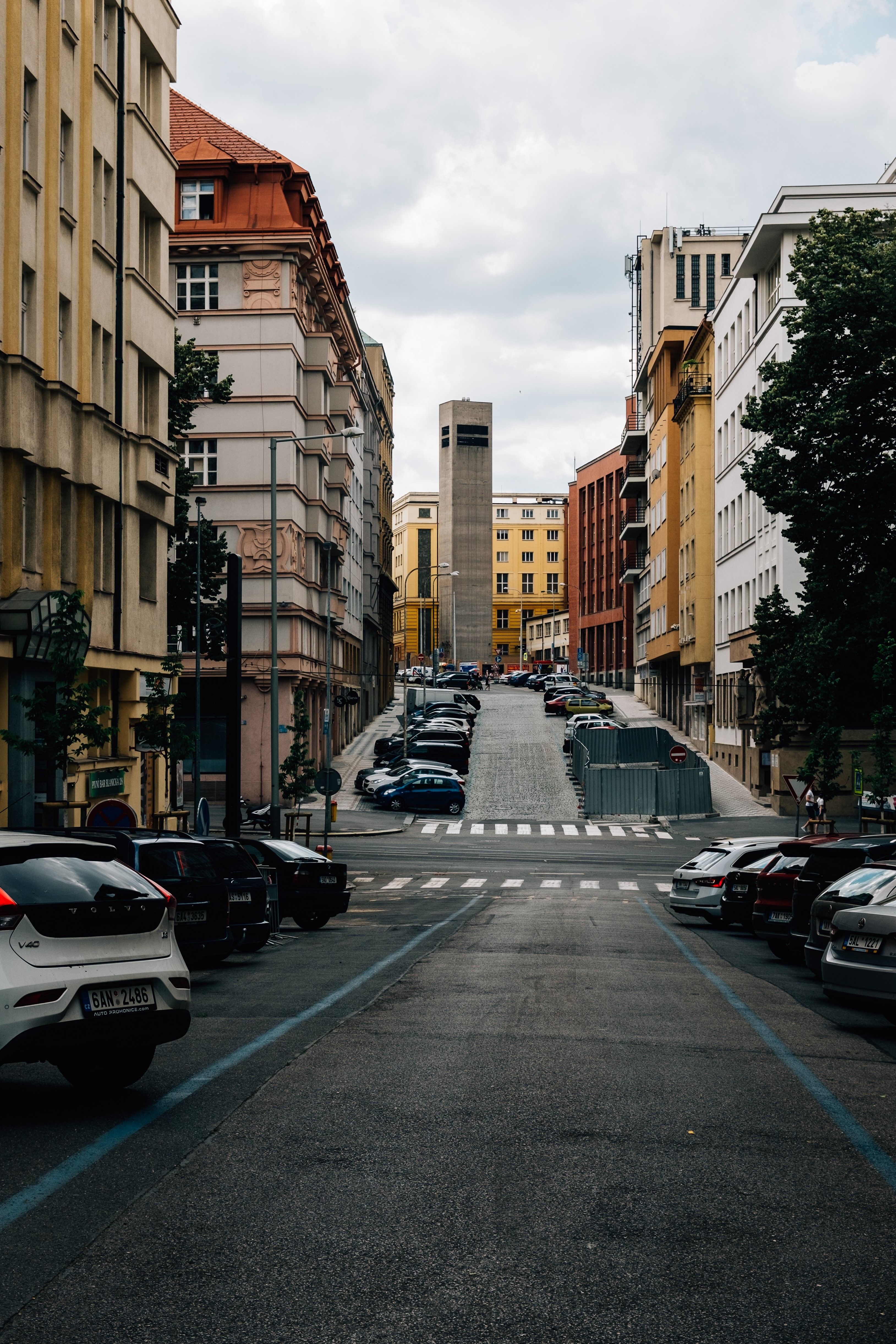 Photo d’une rue calme en ville, bordée de bâtiments colorés et de voitures stationnées
