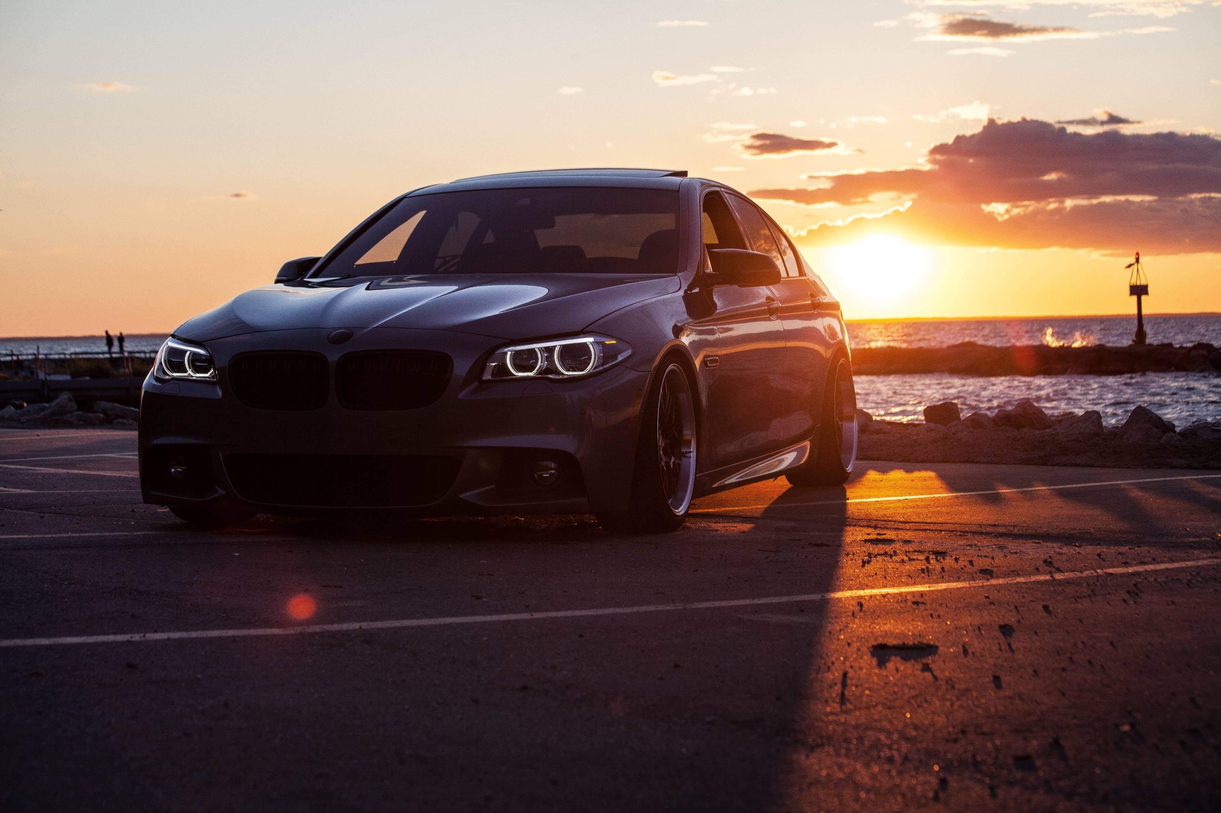 Photo d’une voiture garée au bord de l’eau au coucher du soleil