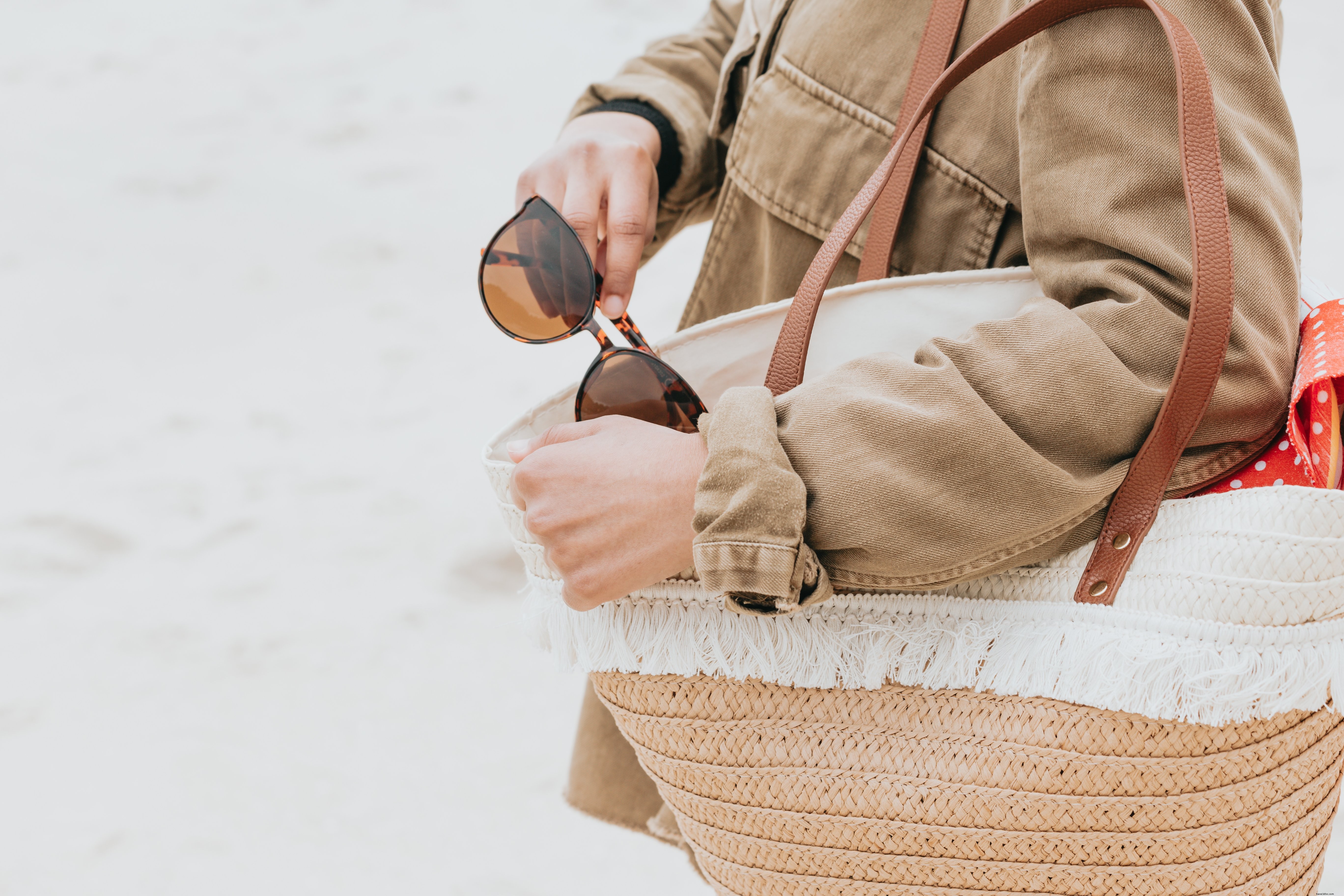 Photo : Elle tient son sac de plage et retire ses lunettes de soleil
