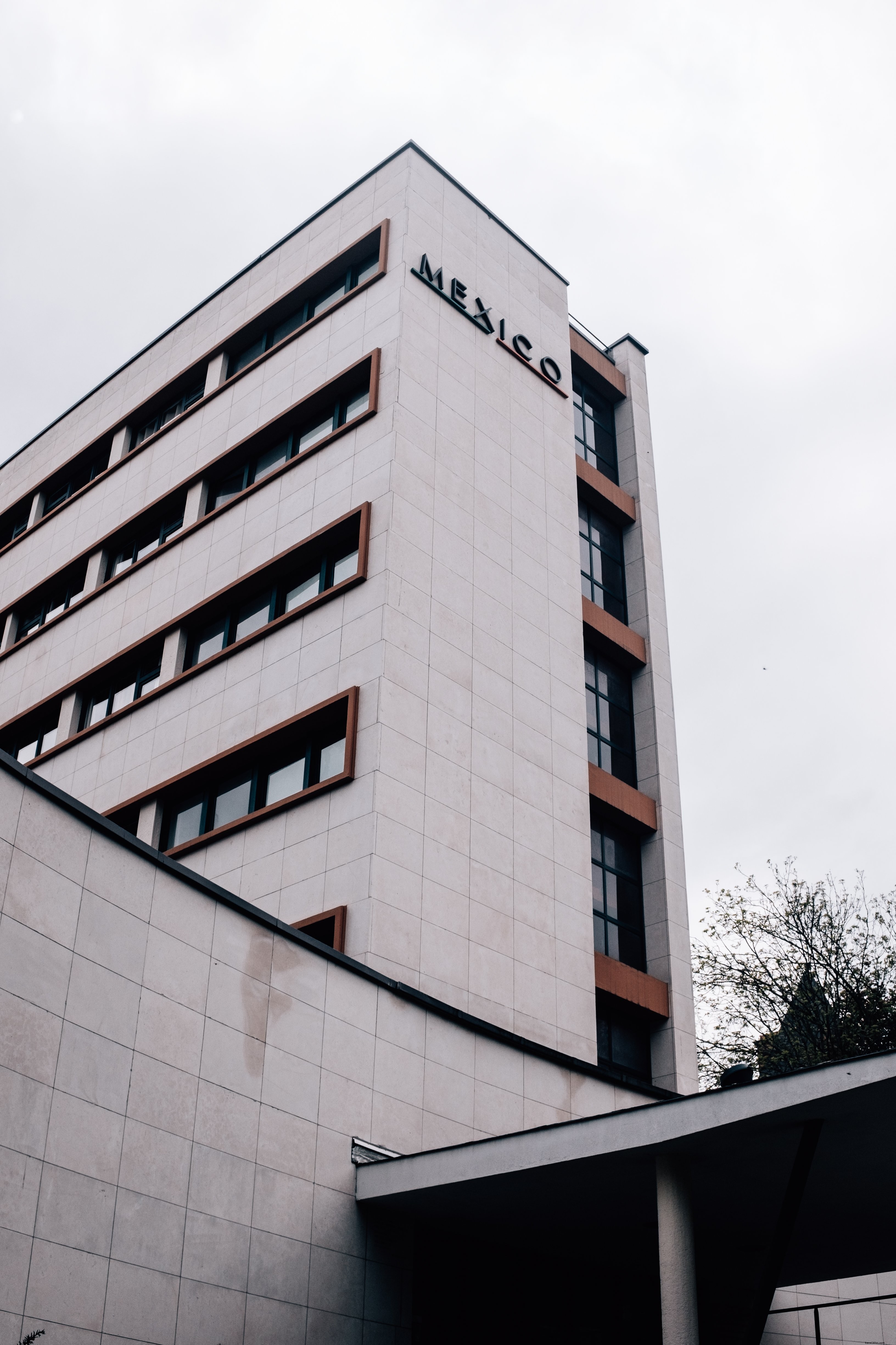 Imposant bâtiment gris arborant le mot « Mexique » en plein centre‑ville