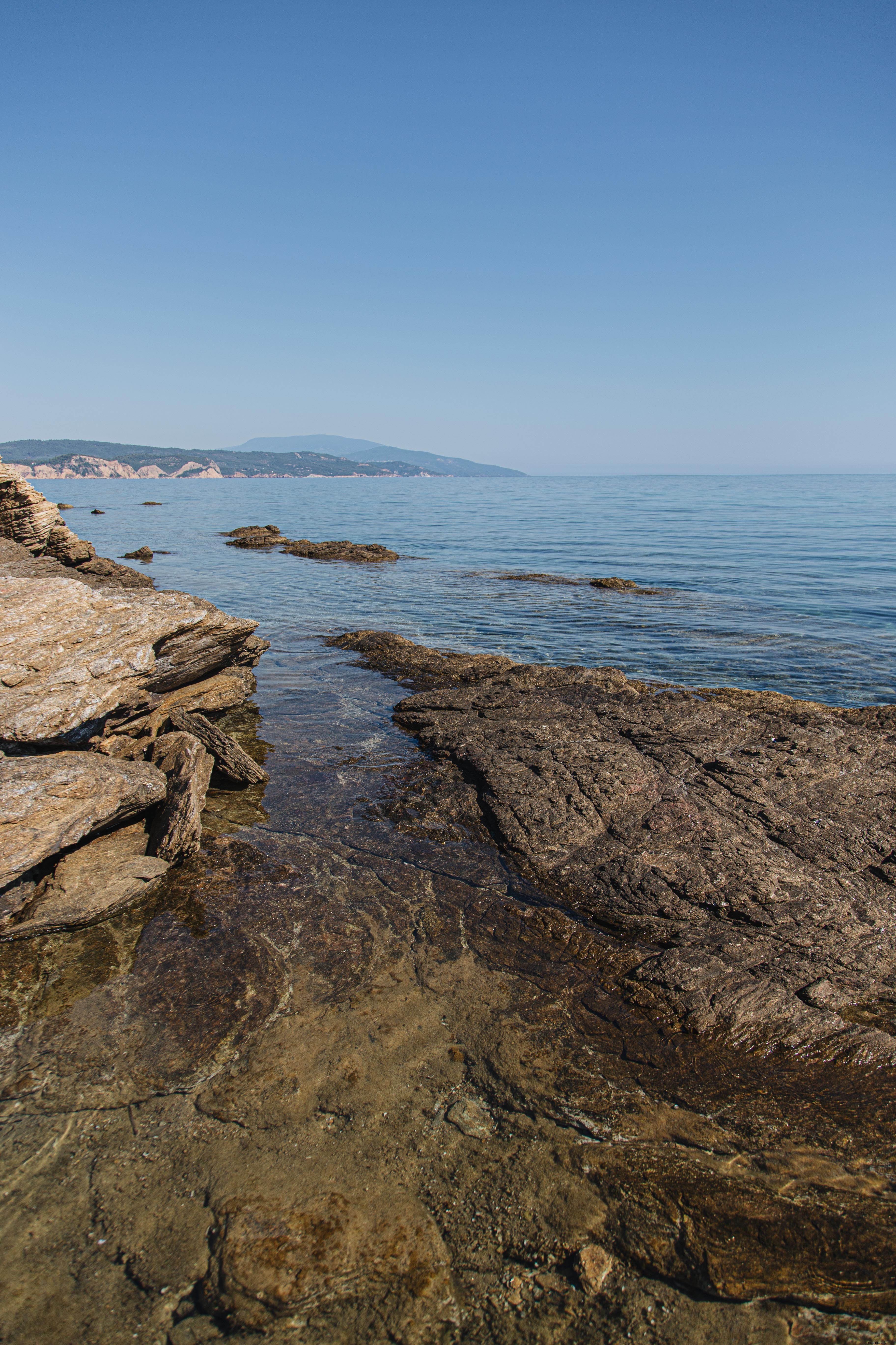 Photo d’une côte rocheuse avec océan ouvert et ciel bleu