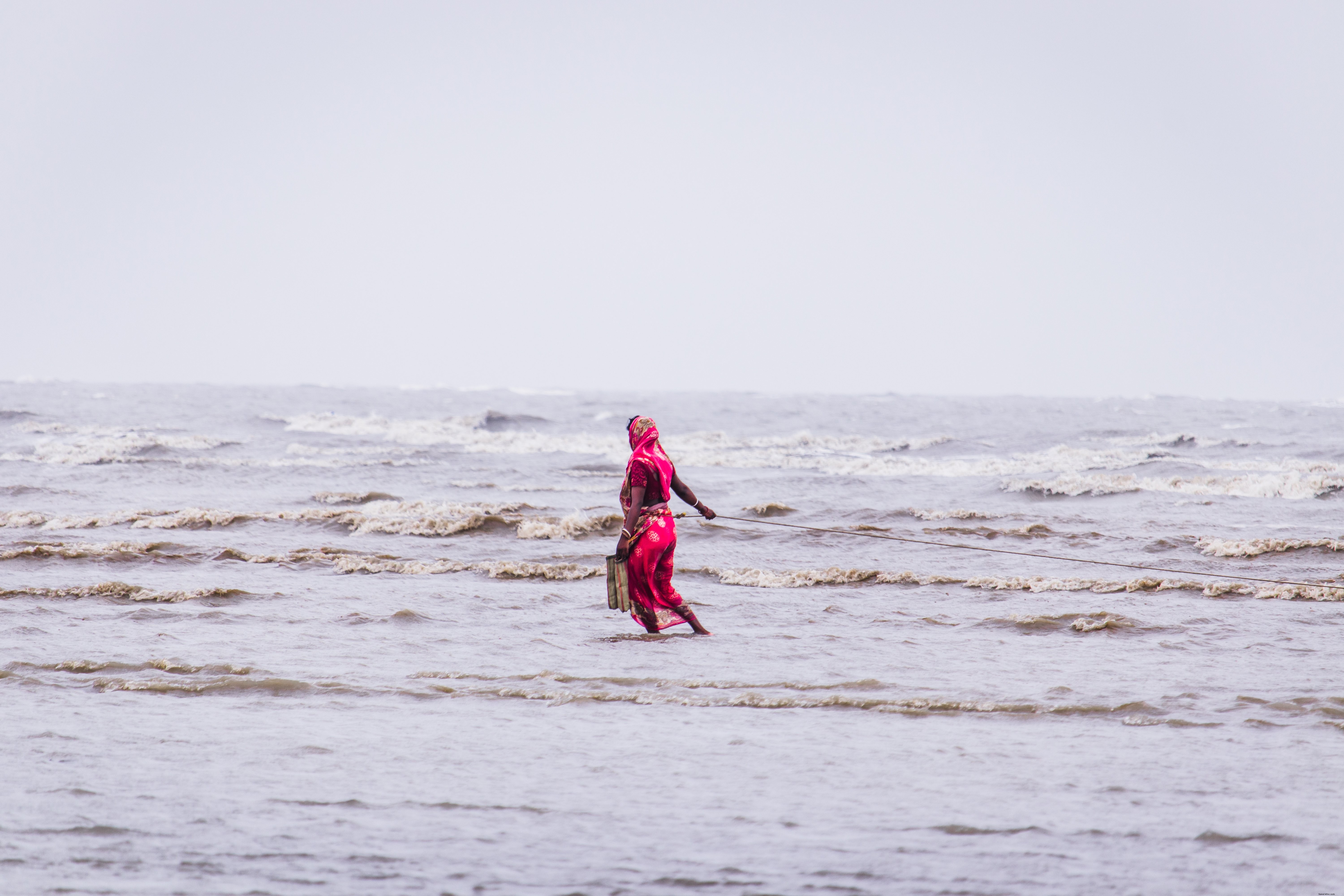 Femme en robe rouge marchant dans l eau peu profonde