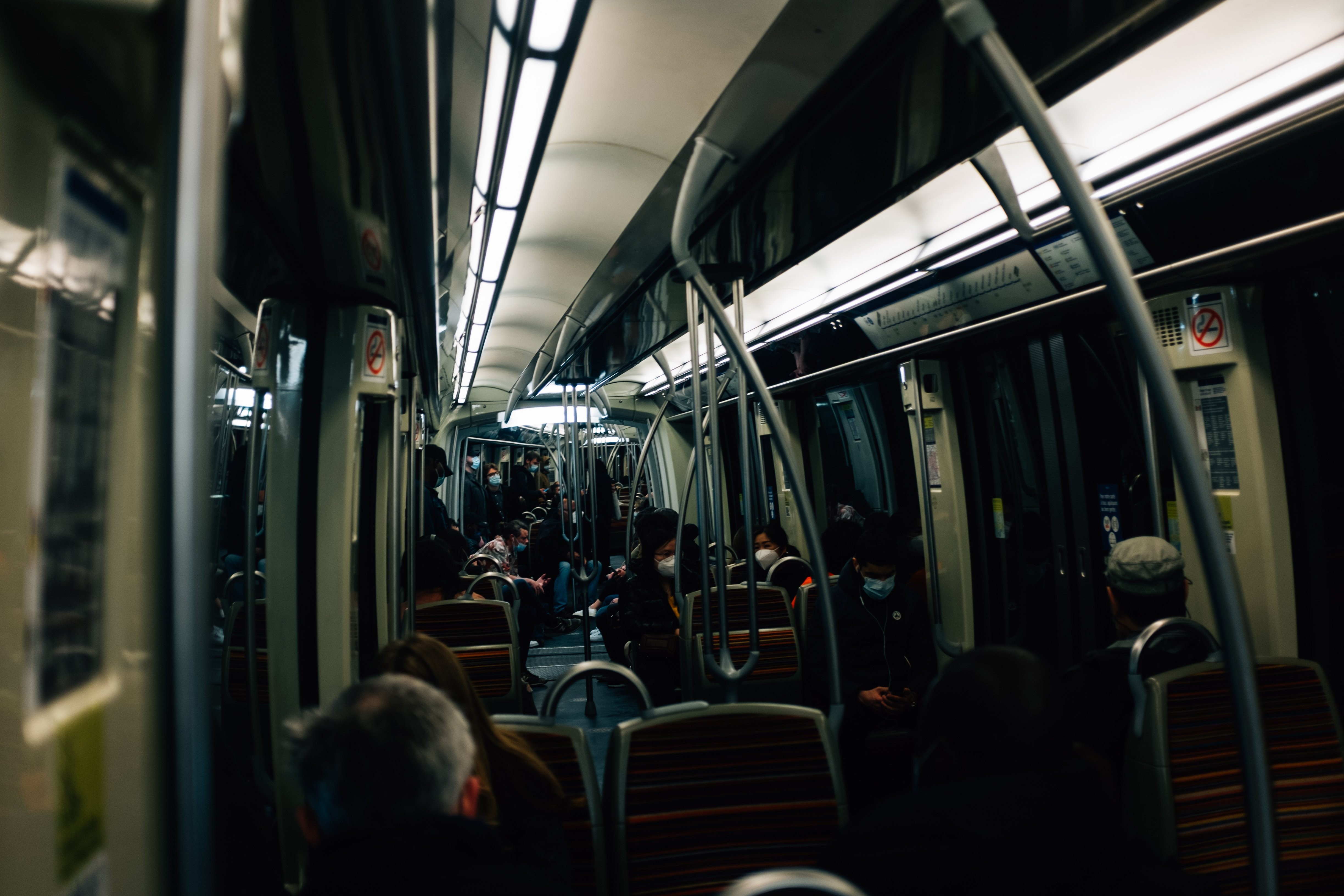 Intérieur d un véhicule de transport en commun faiblement éclairé, passagers près des portes