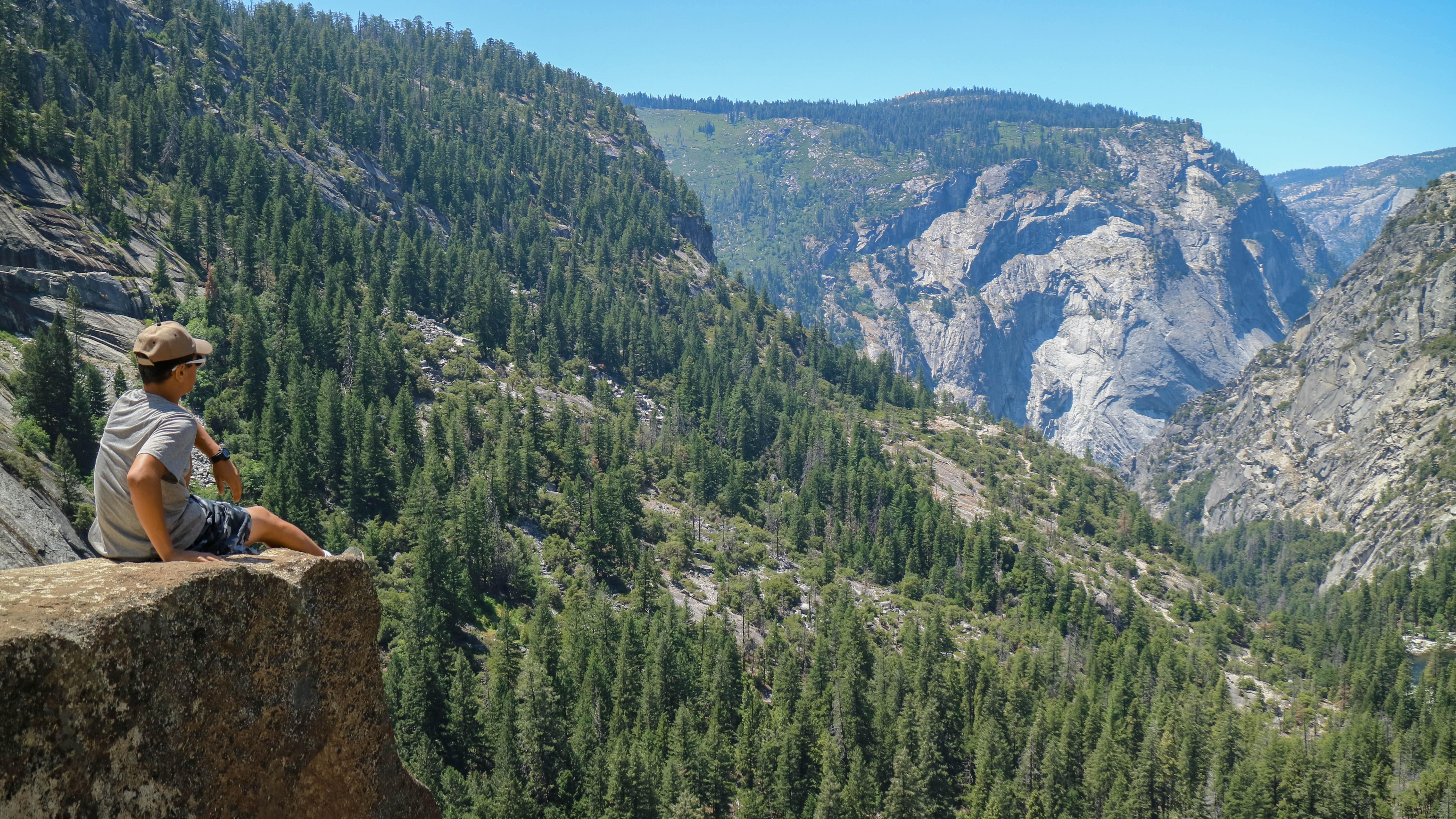 Assis sur le rebord, contemplant les montagnes et la forêt
