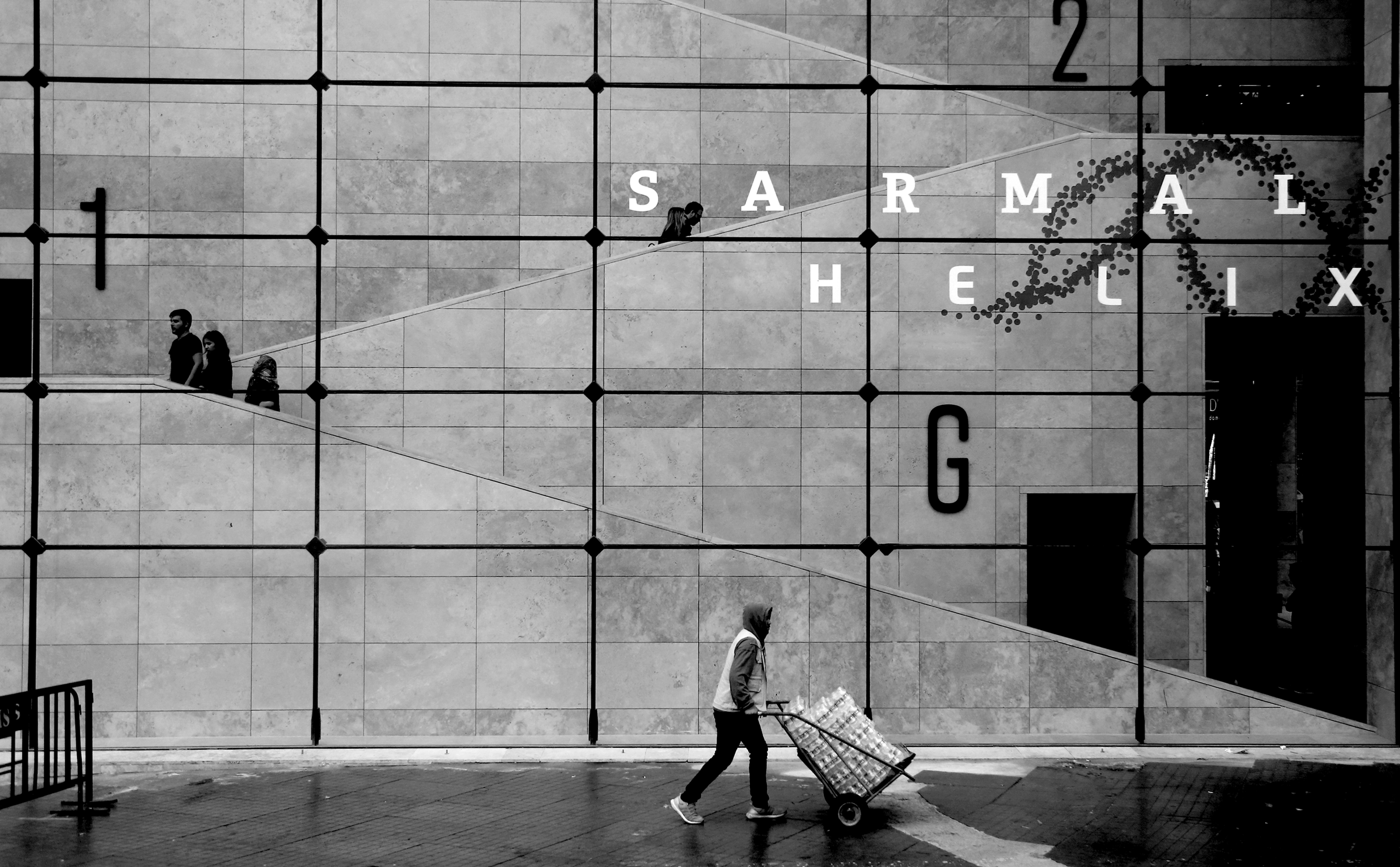 Silhouette solitaire devant une grande fenêtre à grille – Photo en noir et blanc