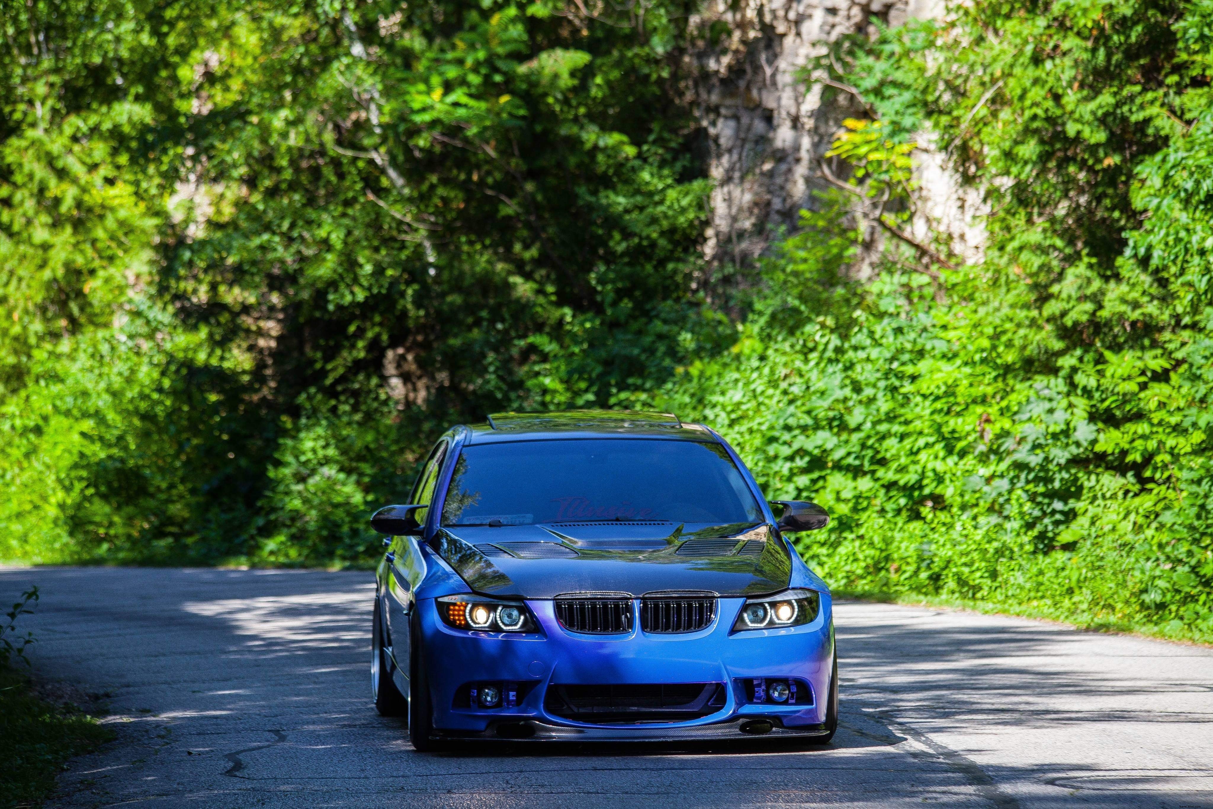 Voiture de sport bleue sur une route de campagne