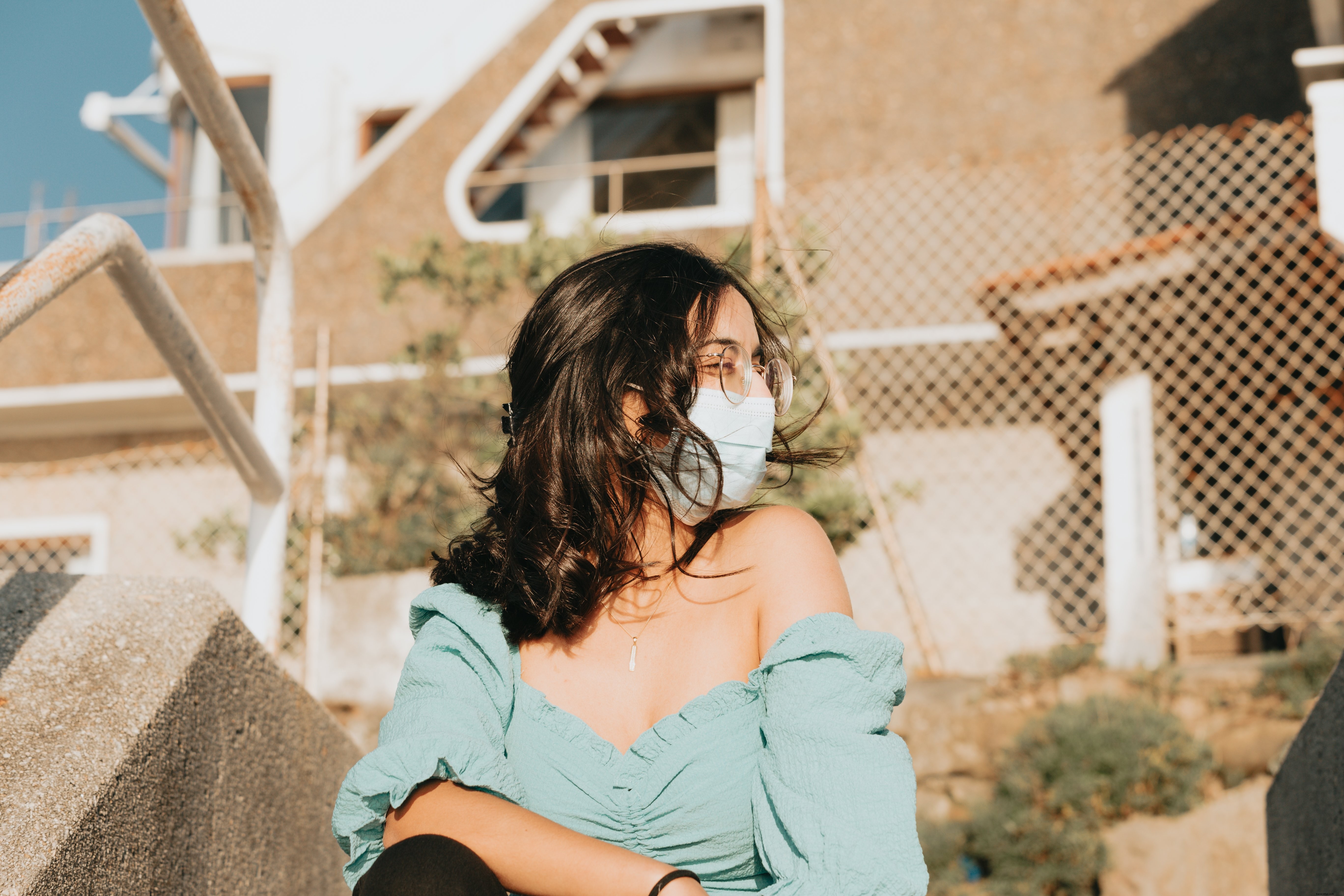 Femme souriante plissant les yeux en portant un masque facial
