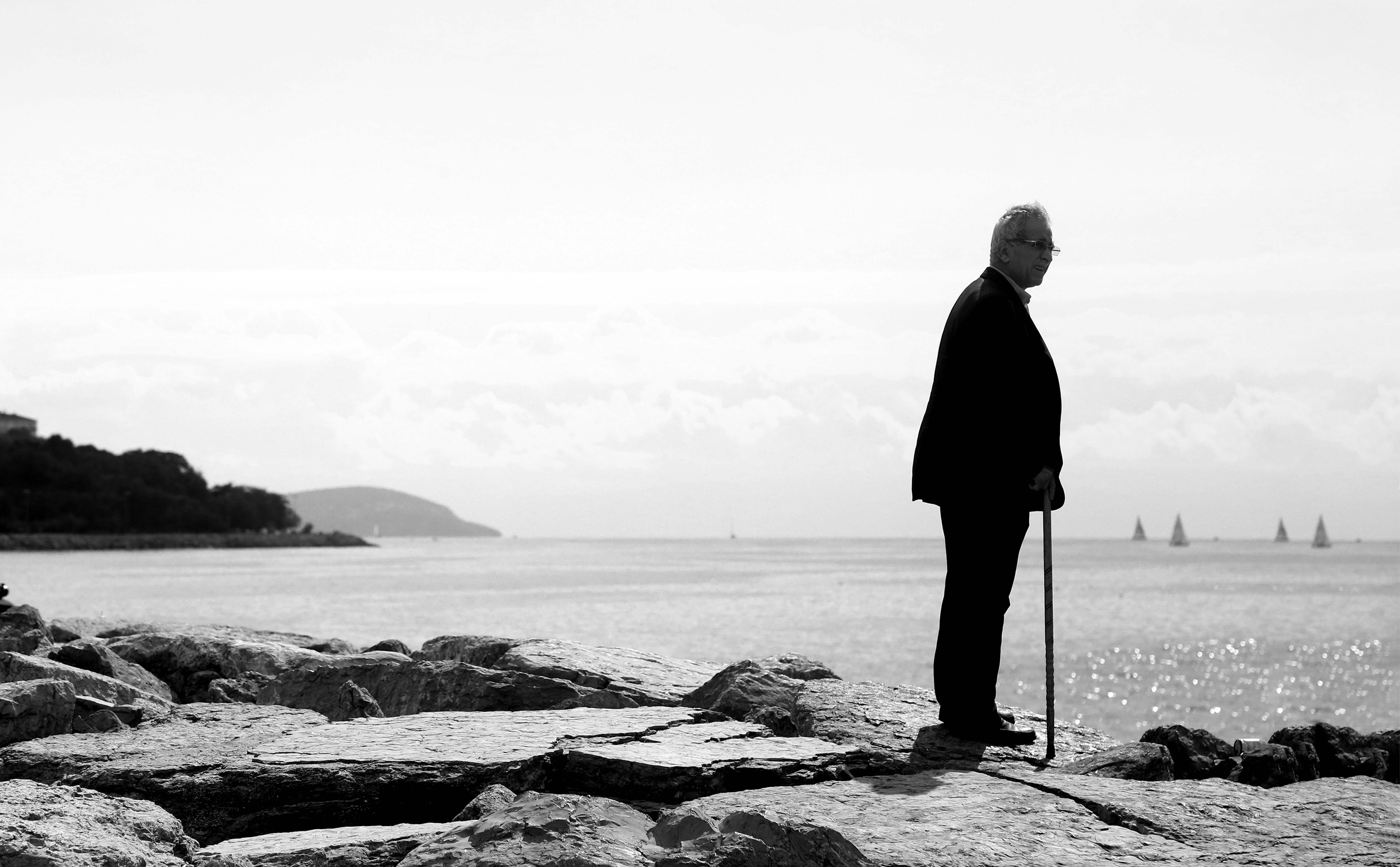 Homme en noir, seul, debout, contemplant l horizon au bord du rivage