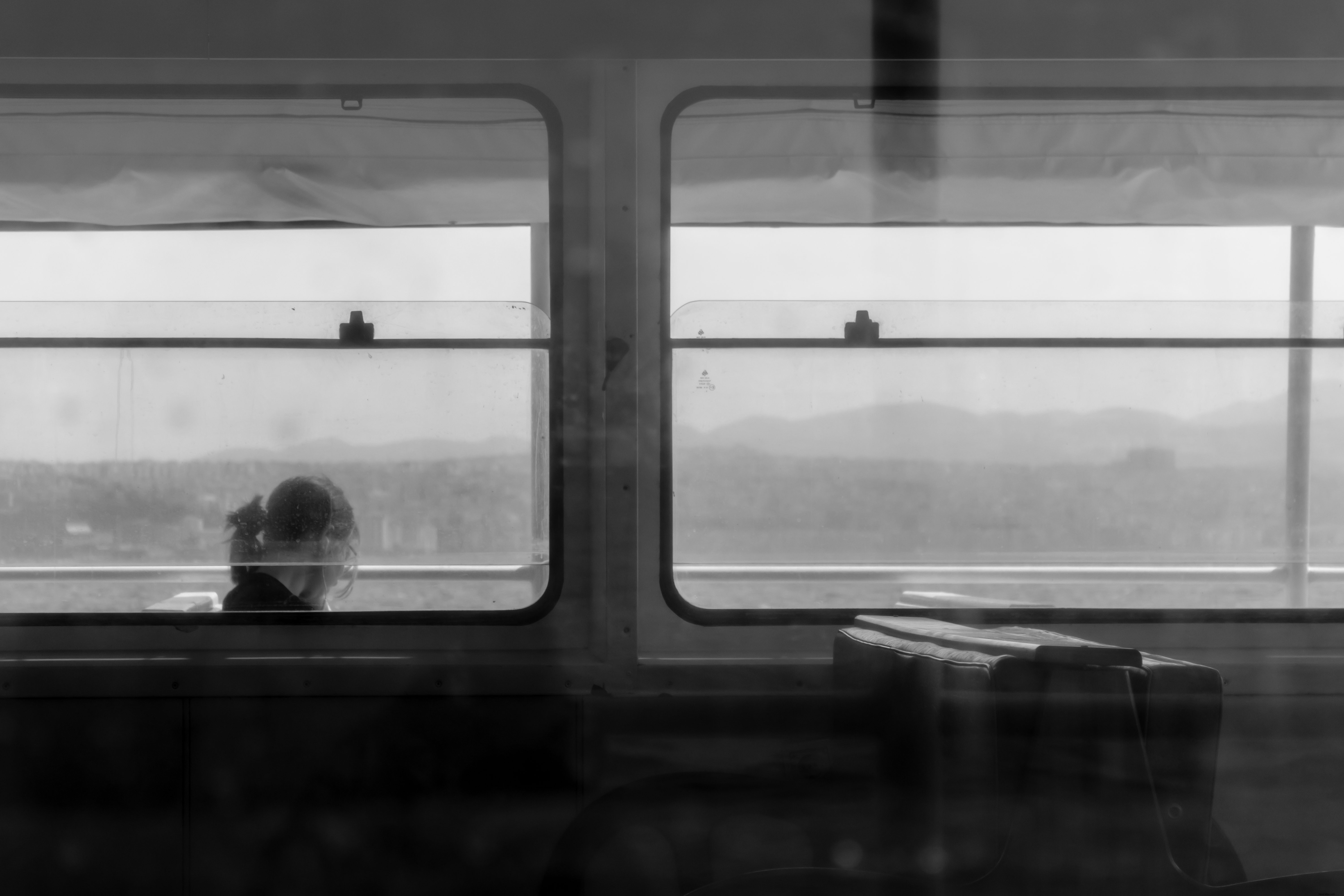Portrait en noir et blanc d une personne assise dans une fenêtre