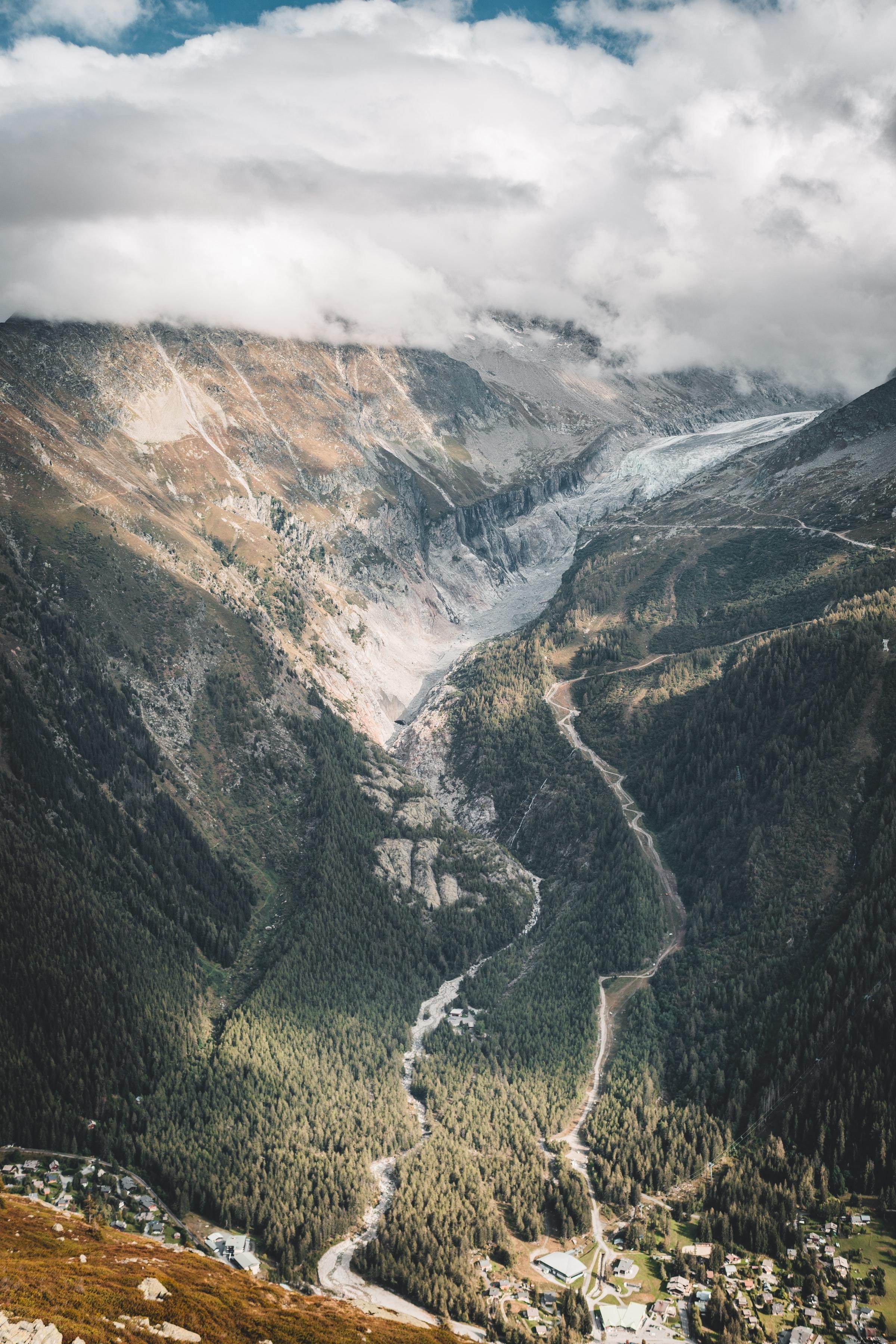 Vallée de montagne verdoyante et route blanche sinueuse