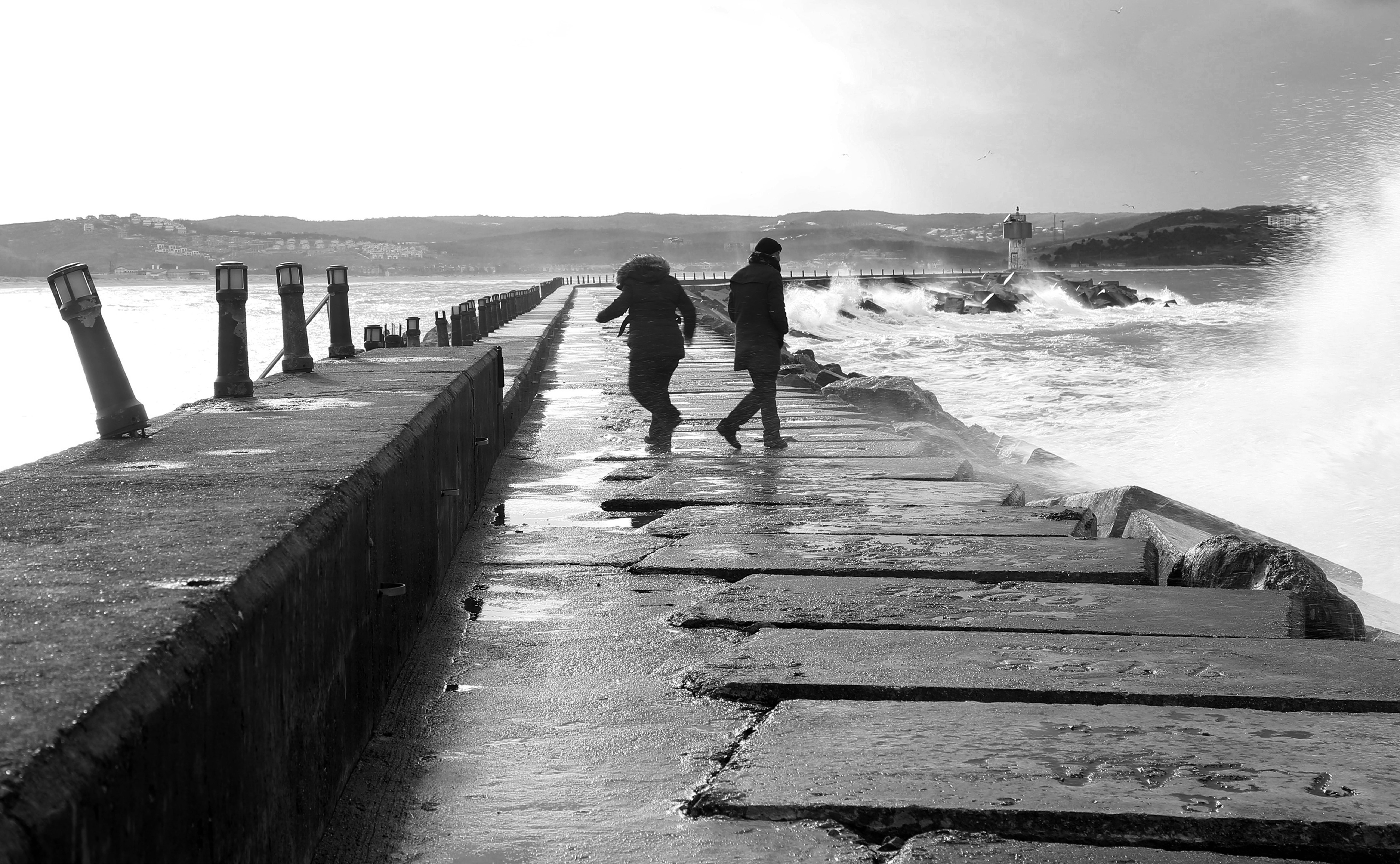 Deux personnes marchant sur la plage de Choppy Ocean Tide – Photo en noir et blanc