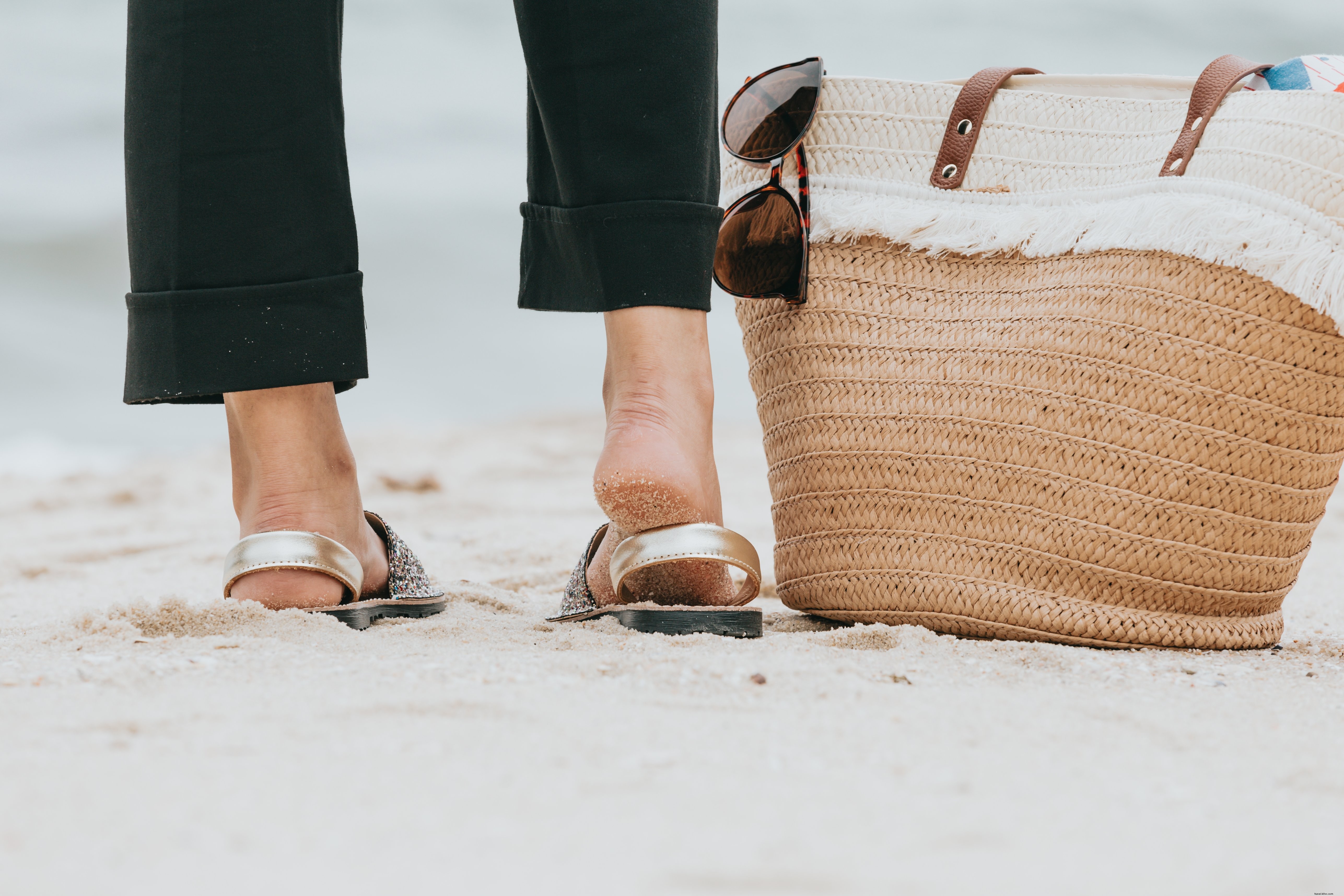 Photo d une jambe sur la plage à côté d un sac de plage