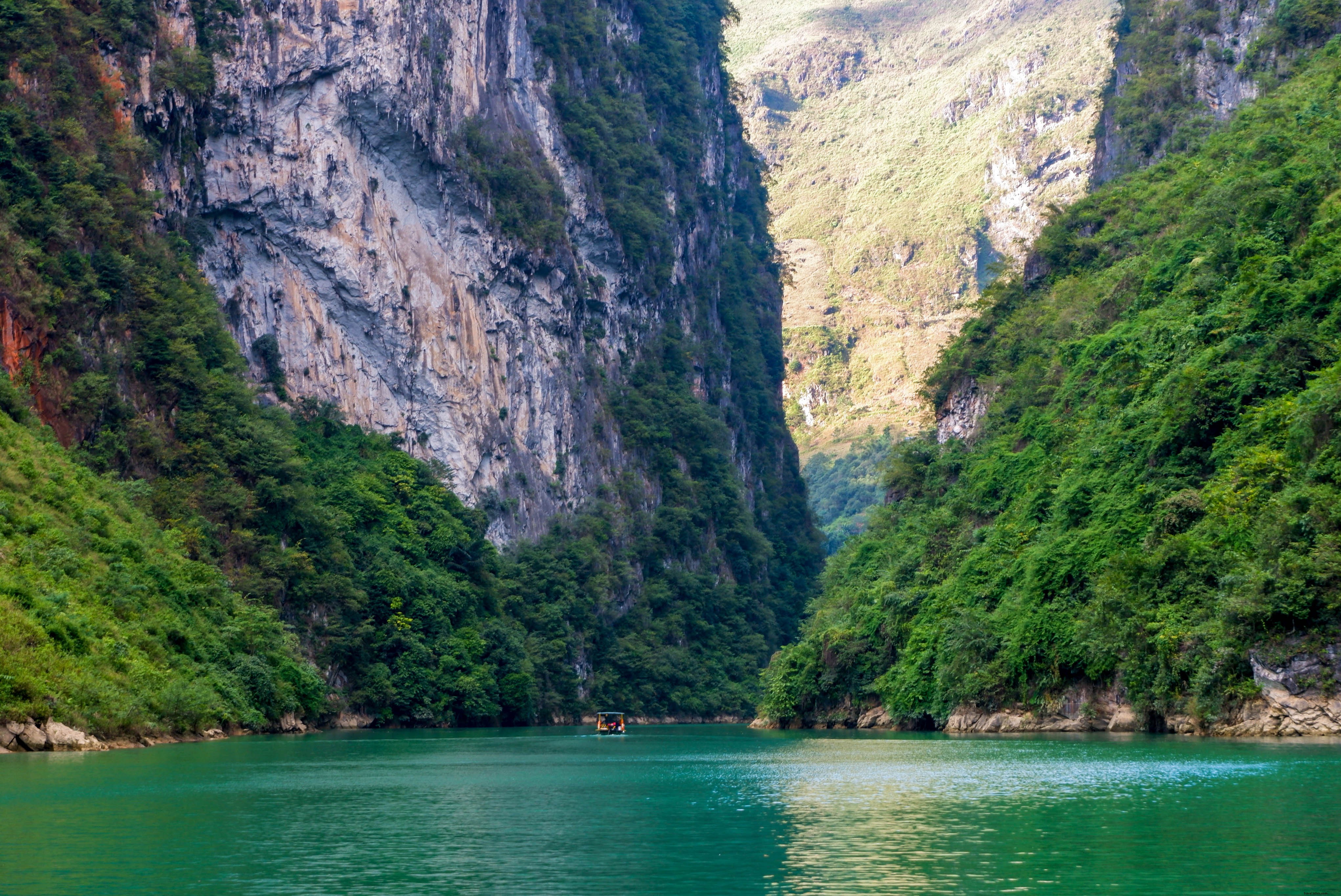 Photo d une eau calme sous une chaîne de montagnes vertes