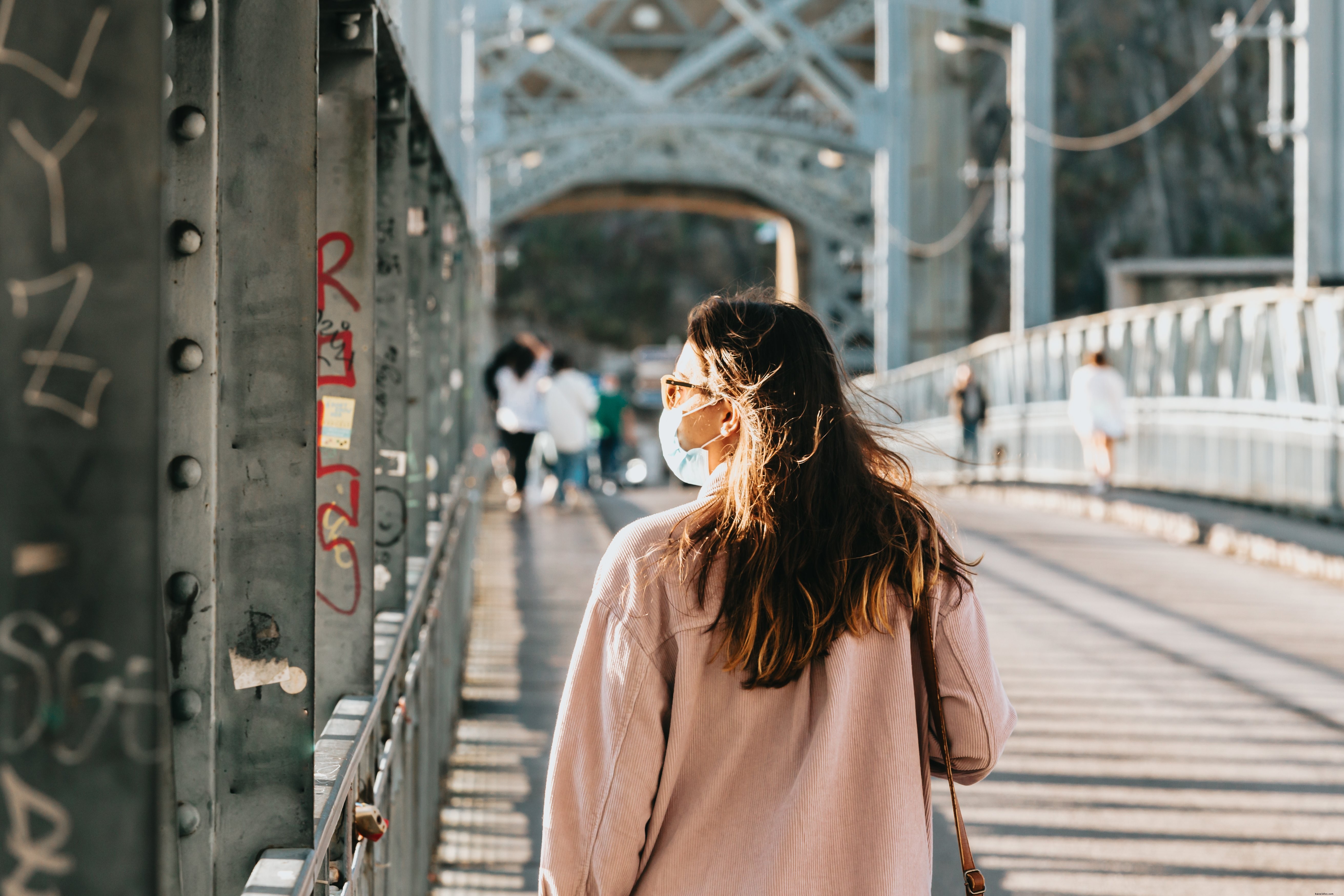 Un piéton masqué déambule sur un pont historique