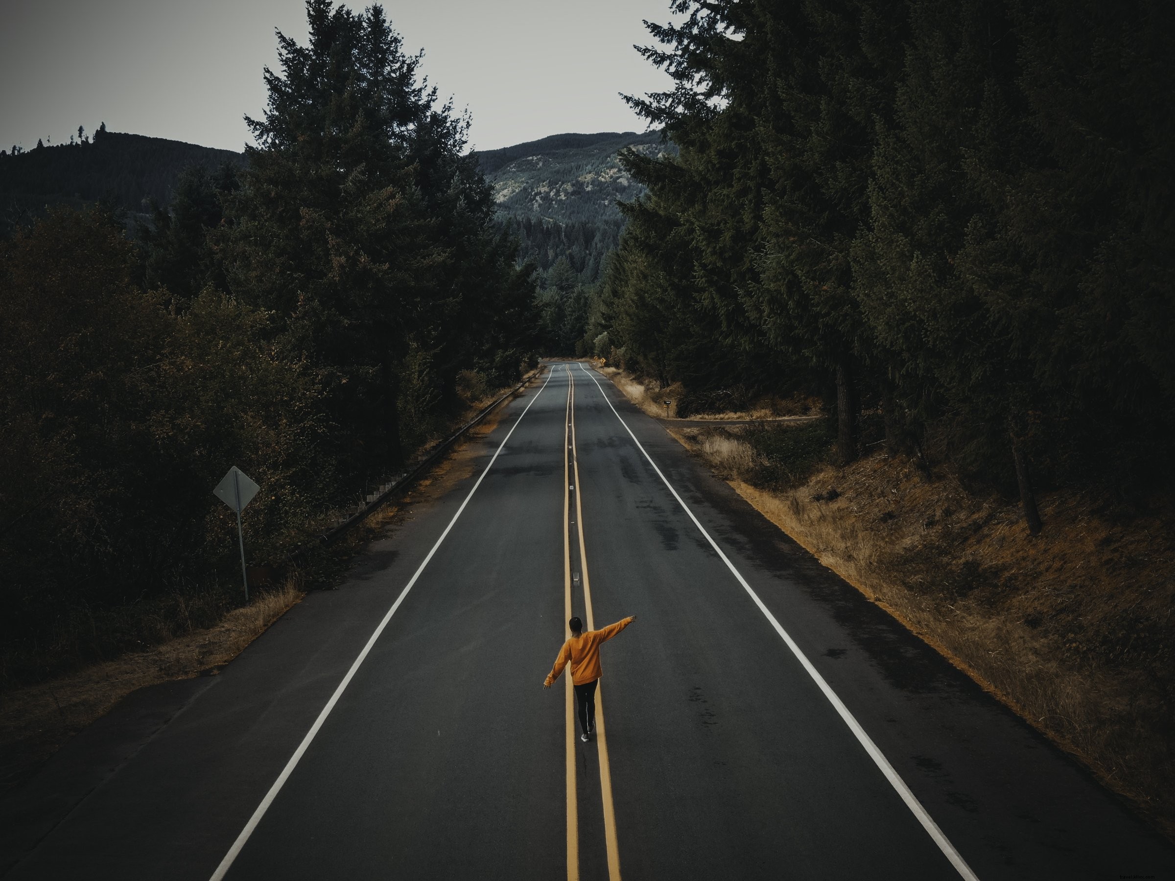 Figure solitaire marchant sur une route de campagne pavée