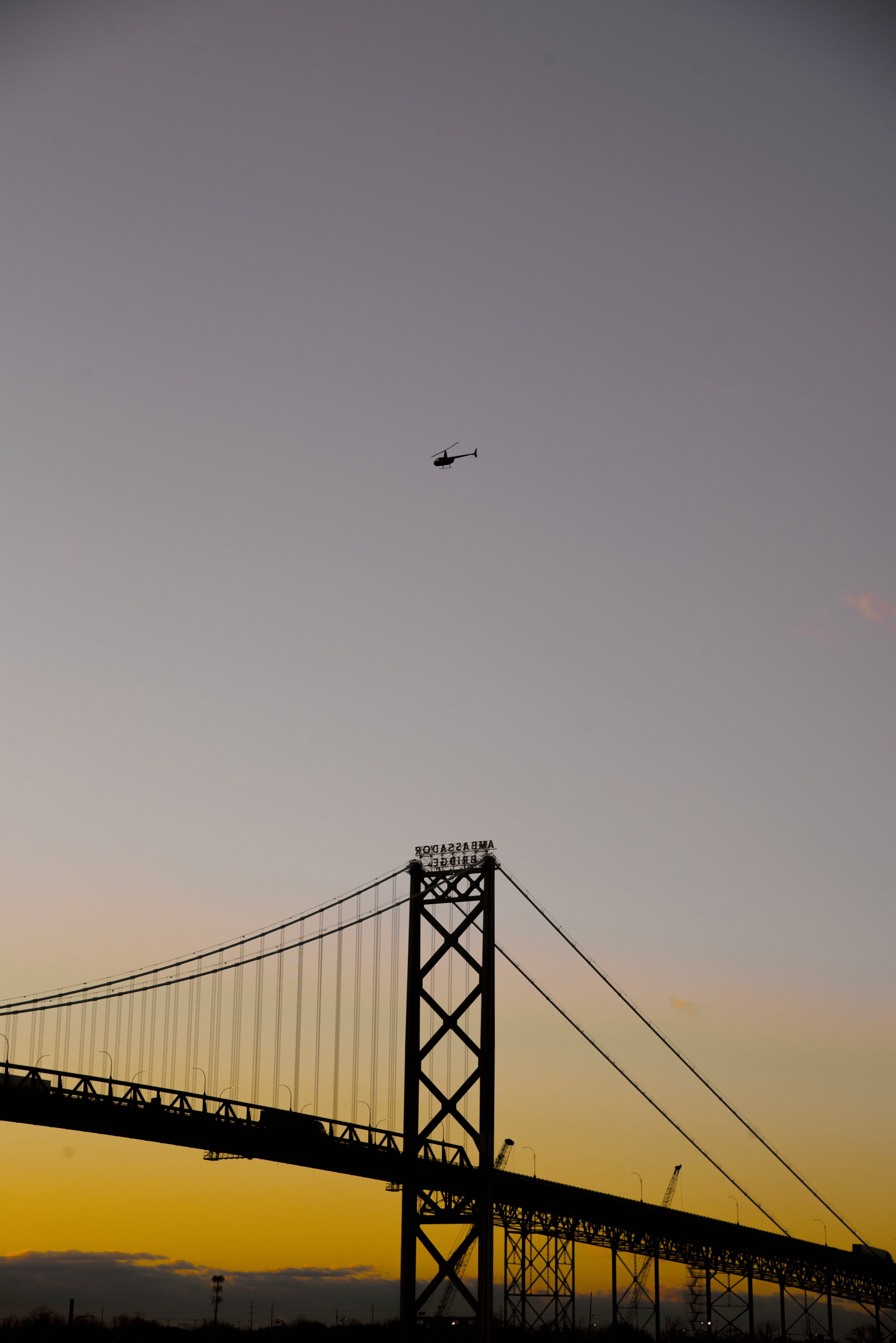 Photo d un grand pont et d un hélicoptère au coucher du soleil