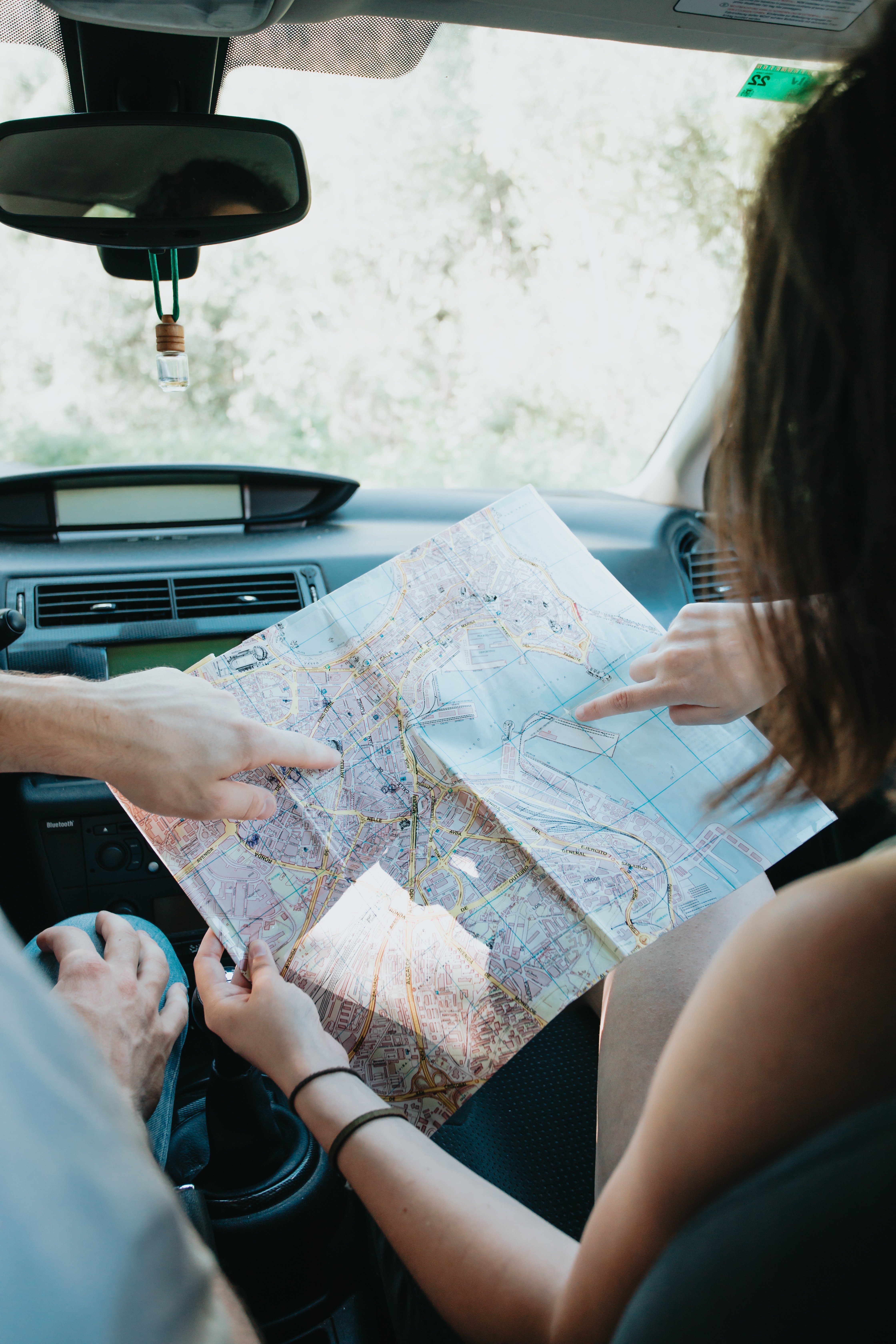 Deux amis consultent une carte à l intérieur d une voiture